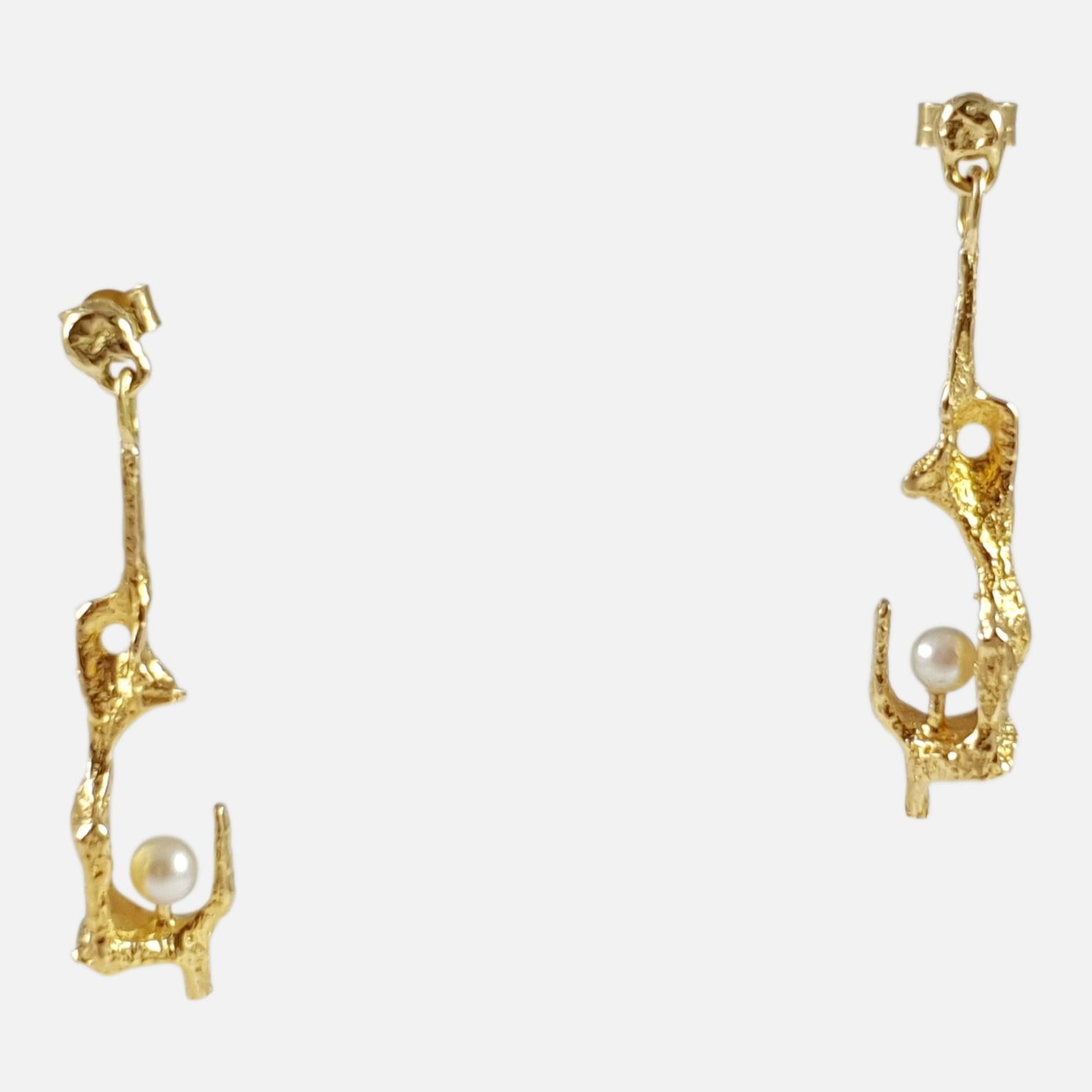 A superb pair of Finnish 18 karat yellow gold cultured pearl earrings designed by Björn Weckström for Lapponia, Finland in the 1960s. The pearls are held in molten finish drops.

The earrings measure 4.3 cm in height x 0.95cm in length.

The
