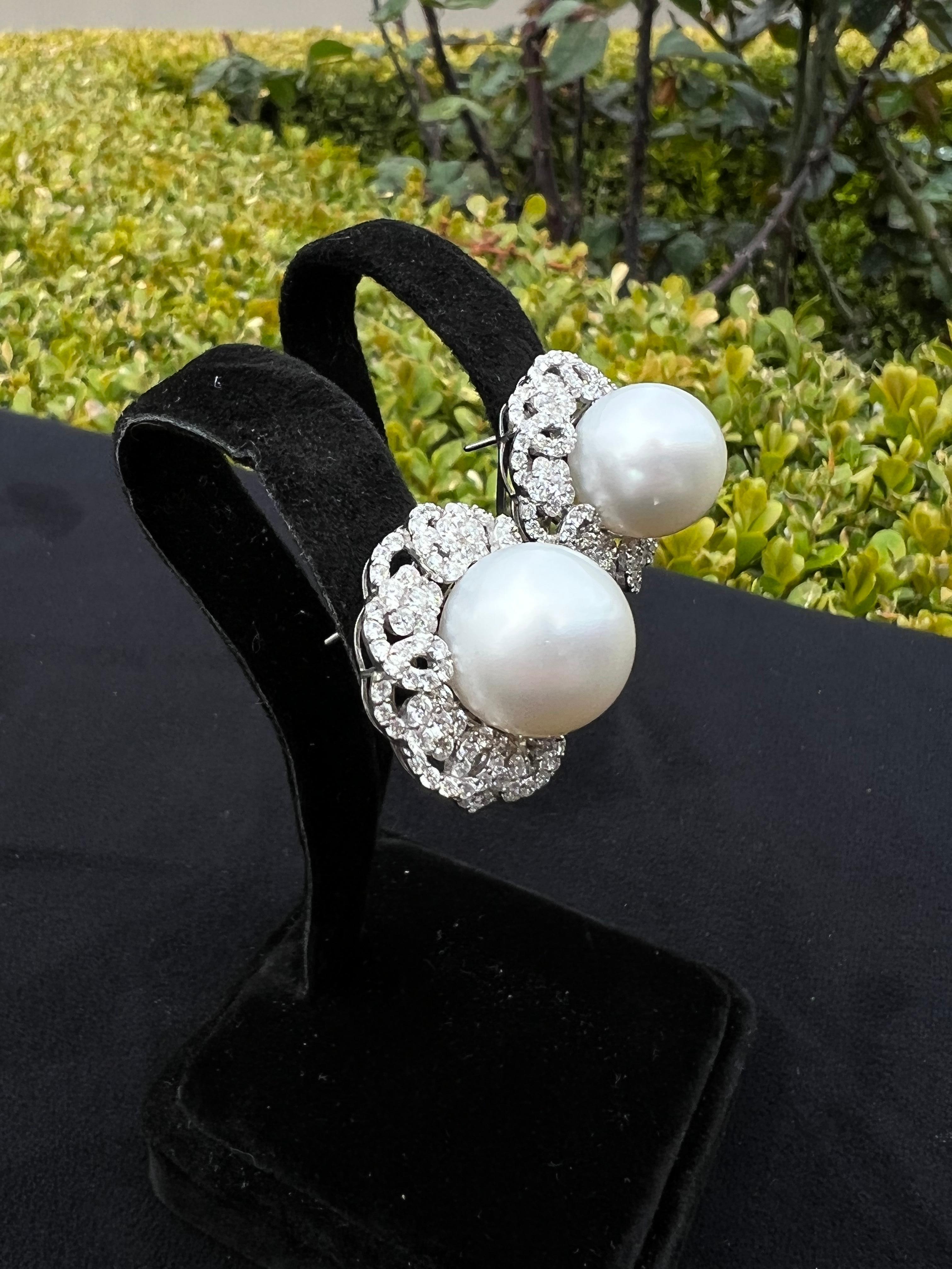 Magnificent, large pair of round 14.35 mm white AAA quality Australian, South Sea pearl earrings, with mirror like luster and shine, are surrounded by round brilliant diamonds set into 18 karat white gold earring mountings. These earrings are