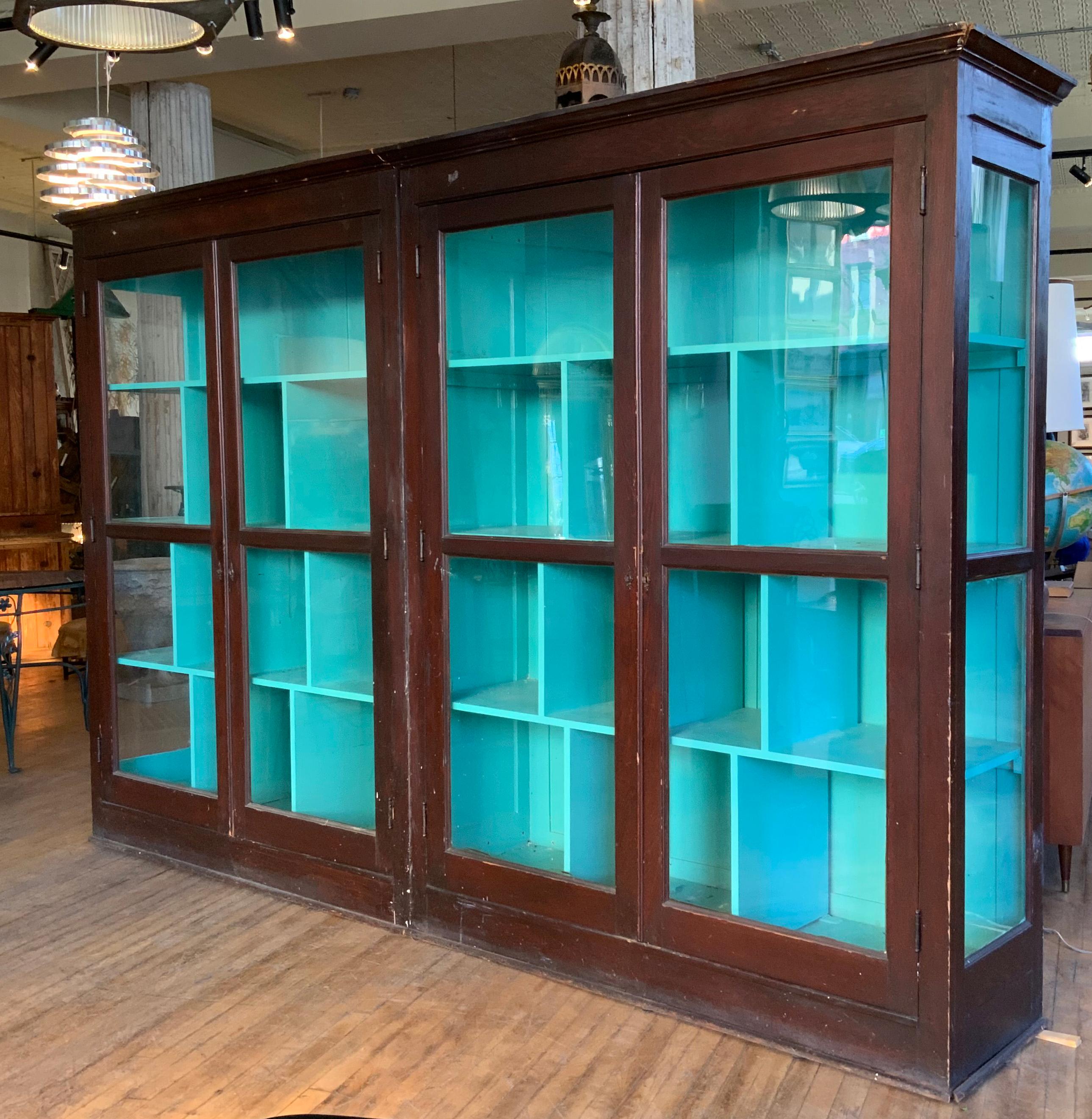 A pair of 1920's glass door cabinets, with oak cases and full height two panel doors with the original glass. these are designed to either be used together, where the moldings match, creating one long run of storage, or separately. one case has full
