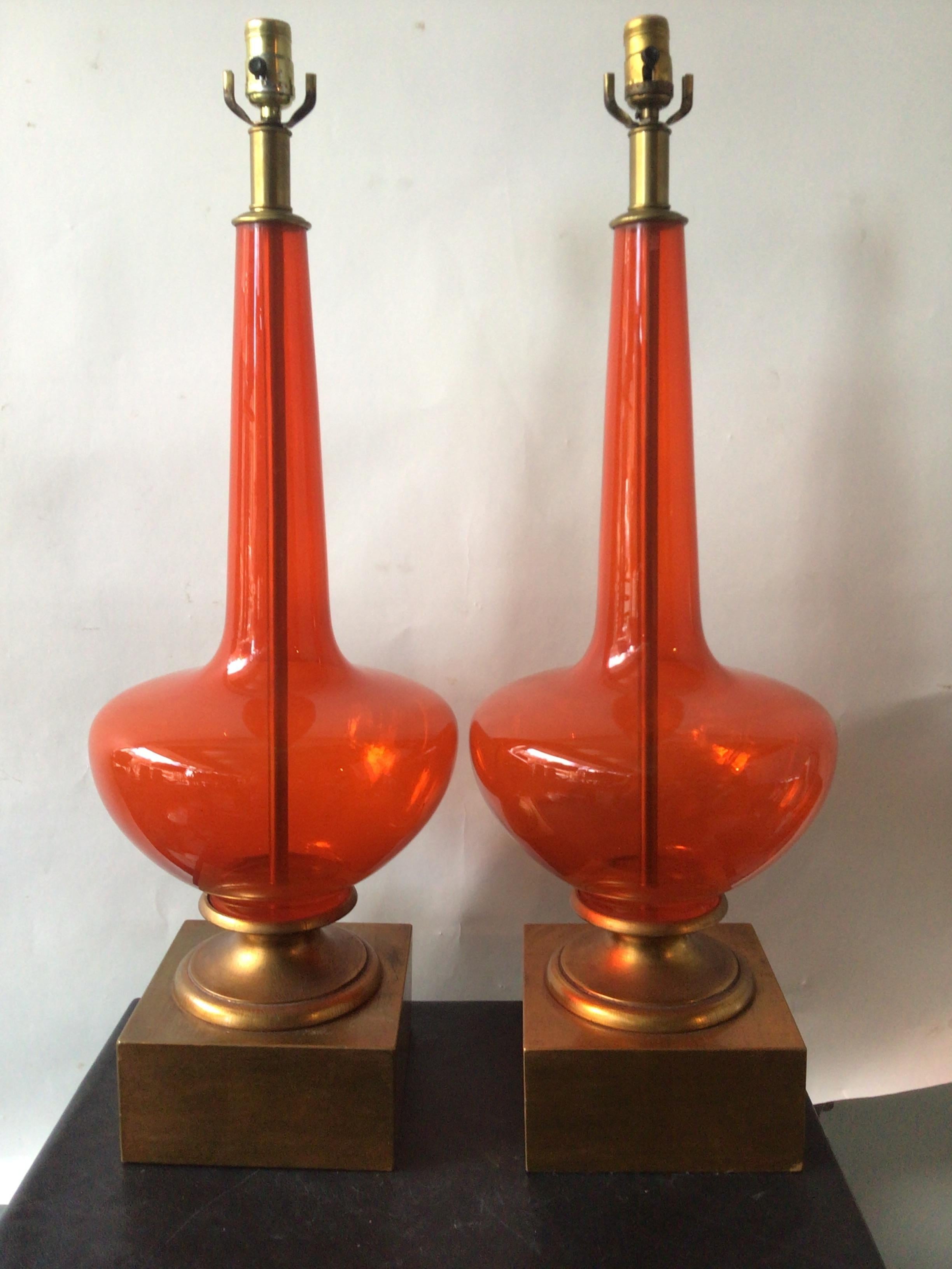 Grande paire de lampes en verre de Murano orange des années 1960 sur des bases en bois doré. Dans un appartement de luxe à New York.
