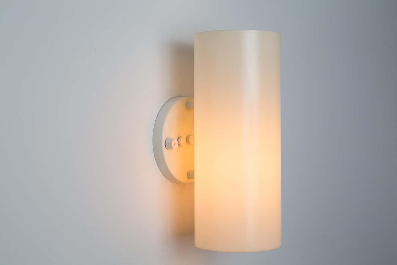 Pair of large 1960s Paul Mayen cylindrical wall lamps for Habitat. An architectural and minimalist design executed in white painted metal and opaline lucite. New rotating on/off switch on circular backplate.

Price is per pair. One pair available