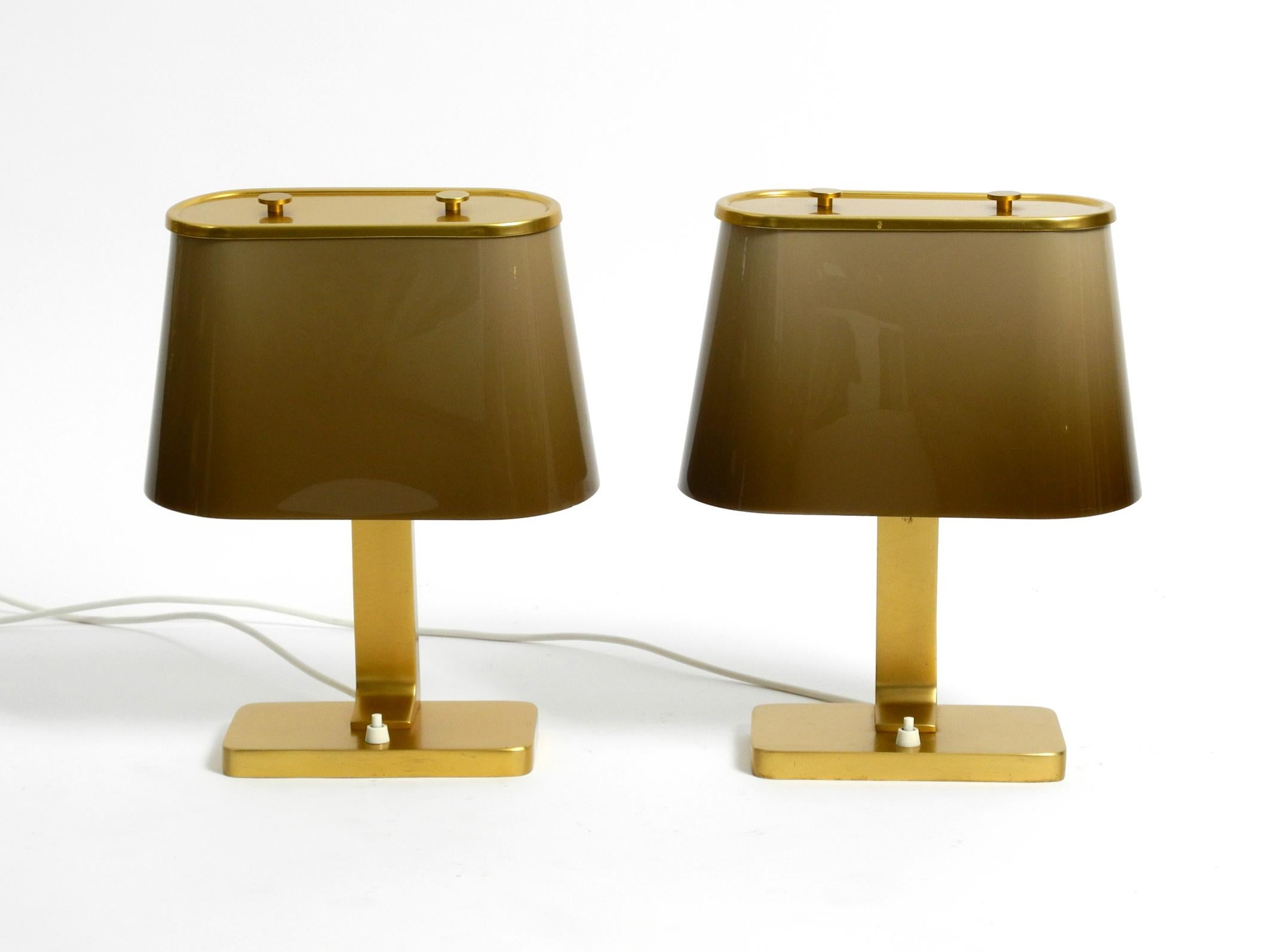 Pair of large rare 1960's Space Age table lamps with plastic shades.
Made in Italy. Great minimalist Space Age design.
Probably made by Guzzini. Reminds strongly of the manufacturer's design.
Heavy cast aluminum base and neck anodized in a golden