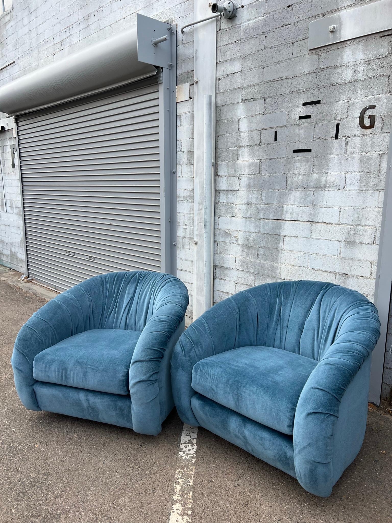 Seeing double. Pair of ridiculously comfortable vintage swiveling lounge chairs in blue velvet. Attributed to Milo Baughman for Directional. Ruched 360° seat backs with plush cushions. They both rock and swivel. 

These are the perfect functional