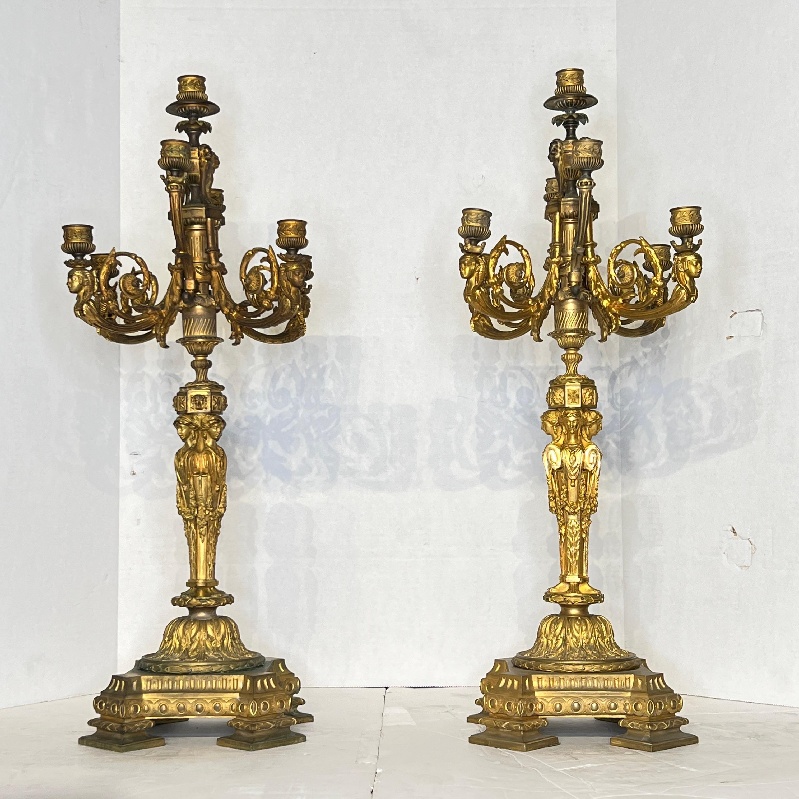 Pair of large gilt bronze candelabra from the Egyptian Revival period, with seven lights and finely cast figurative designs.