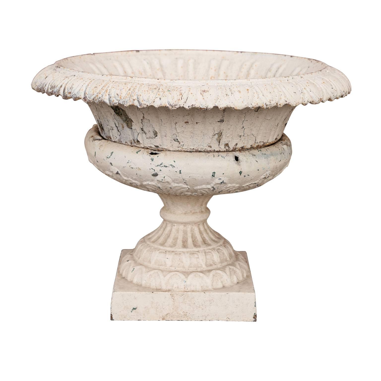 Pair of French cast iron garden urns. Dated to the late 19th century and finished in old white paint. Each cast iron urn is comprised of three segments.

Note: Original/early finish on antique and vintage metal will include some, or all, of the