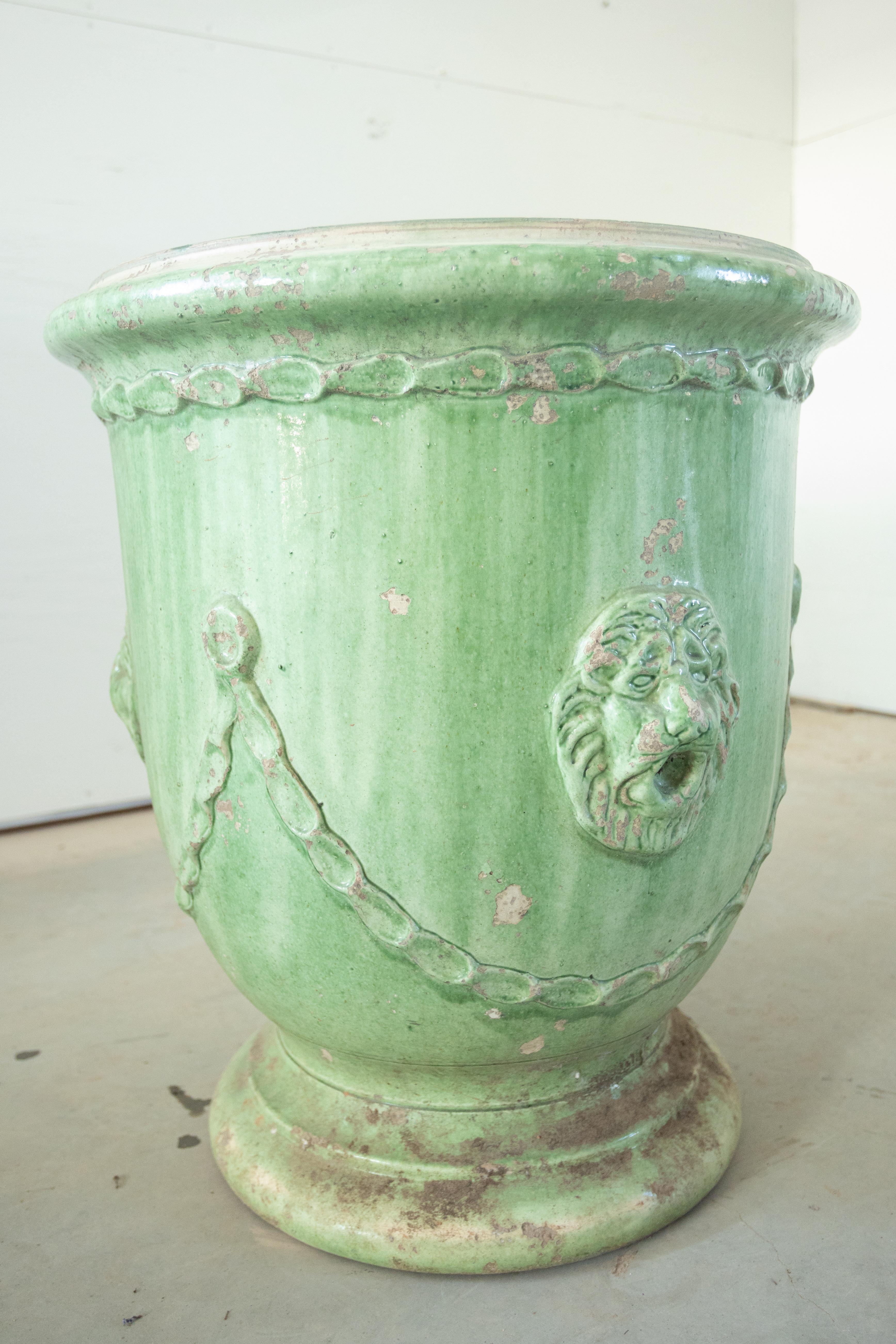This exquisite pair of 19th-century French Anduze jars embodies the timeless elegance of traditional Provençal craftsmanship. Handcrafted in the Anduze region of southern France, these green glazed terracotta planters are adorned with classic