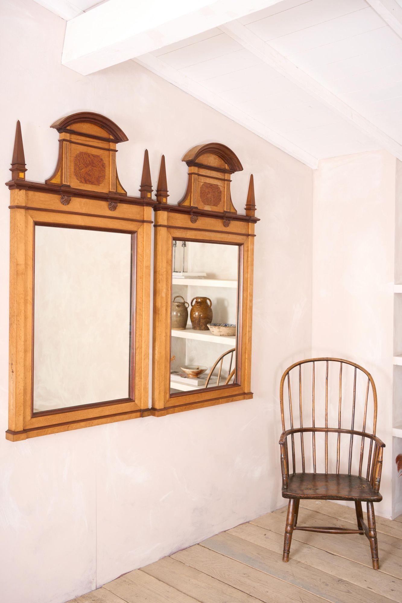 These are a striking pair of late 19th century Early 20th century Maple and walnut wall mirrors. Their design is elegant and would look incredible in a both modern and traditional interiors. These mirror are in honest aged condition with no major