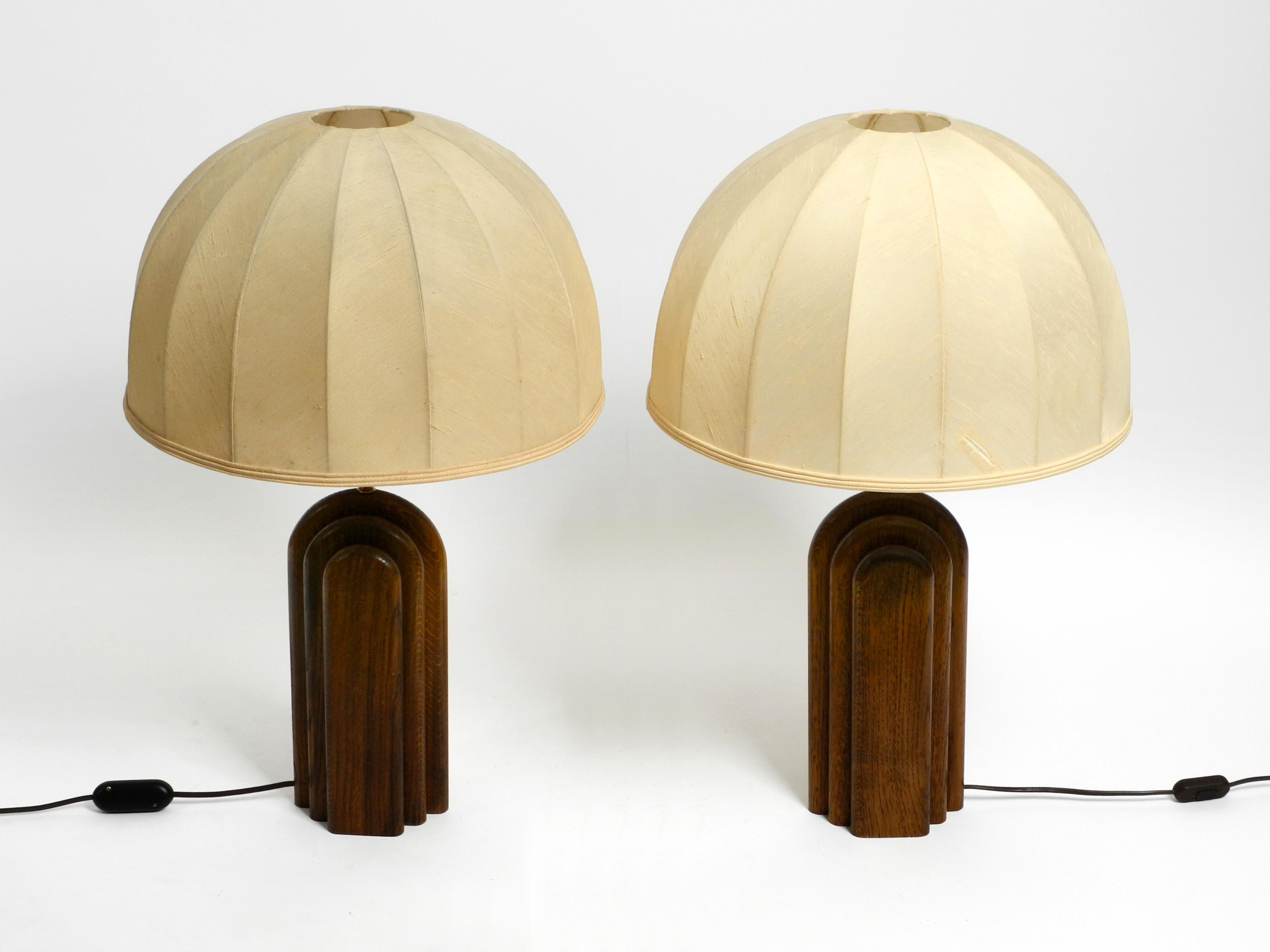 Pair of large, exceptional 1960s table lamps by Temde. Made in Switzerland.
Solid teak frame in Art Deco style.
The large original shades are made of wild silk.
One shade has been repaired in two places.
The shades can also be newly