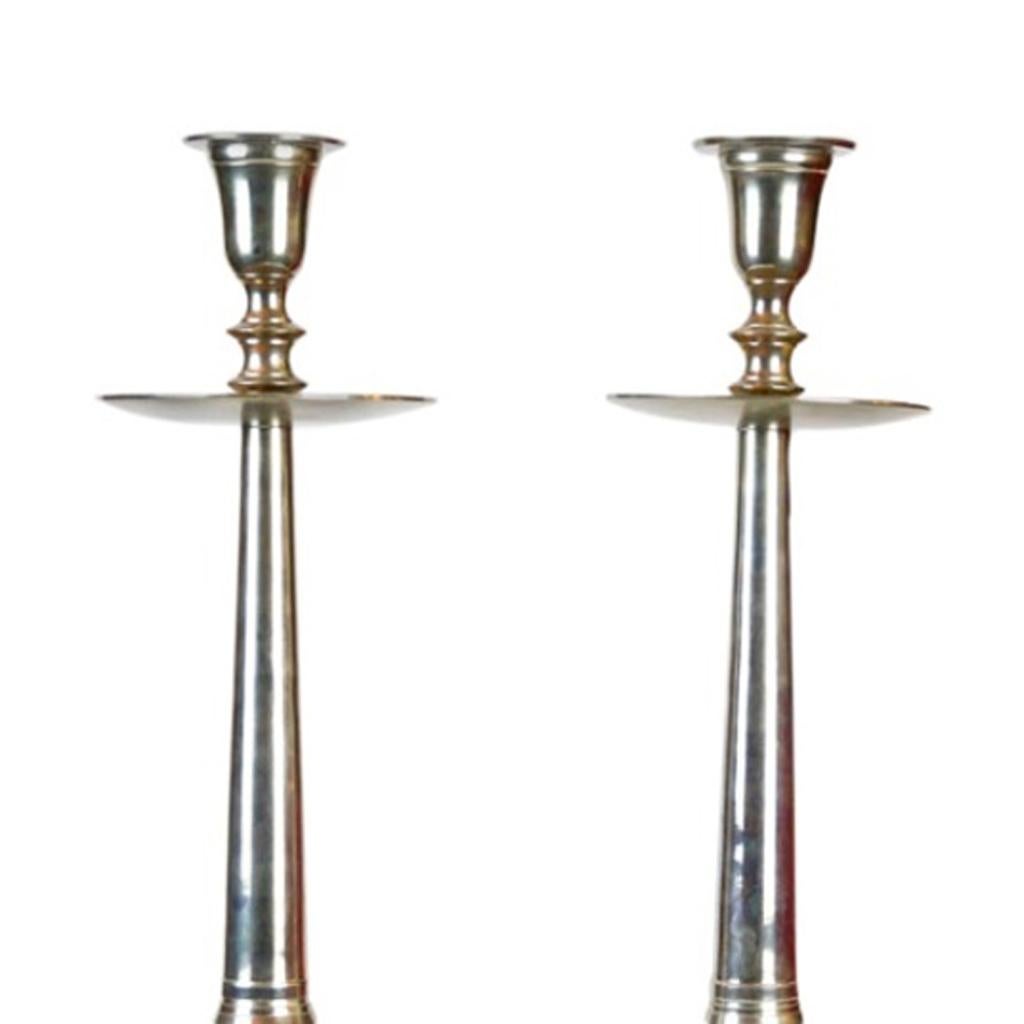 This is a pair of altar candlesticks of the modern age right at the beginning of the last century. Here forms of the classicism in modern kind and execution were combined with each other. The candlesticks are made of brass and the nickel plating