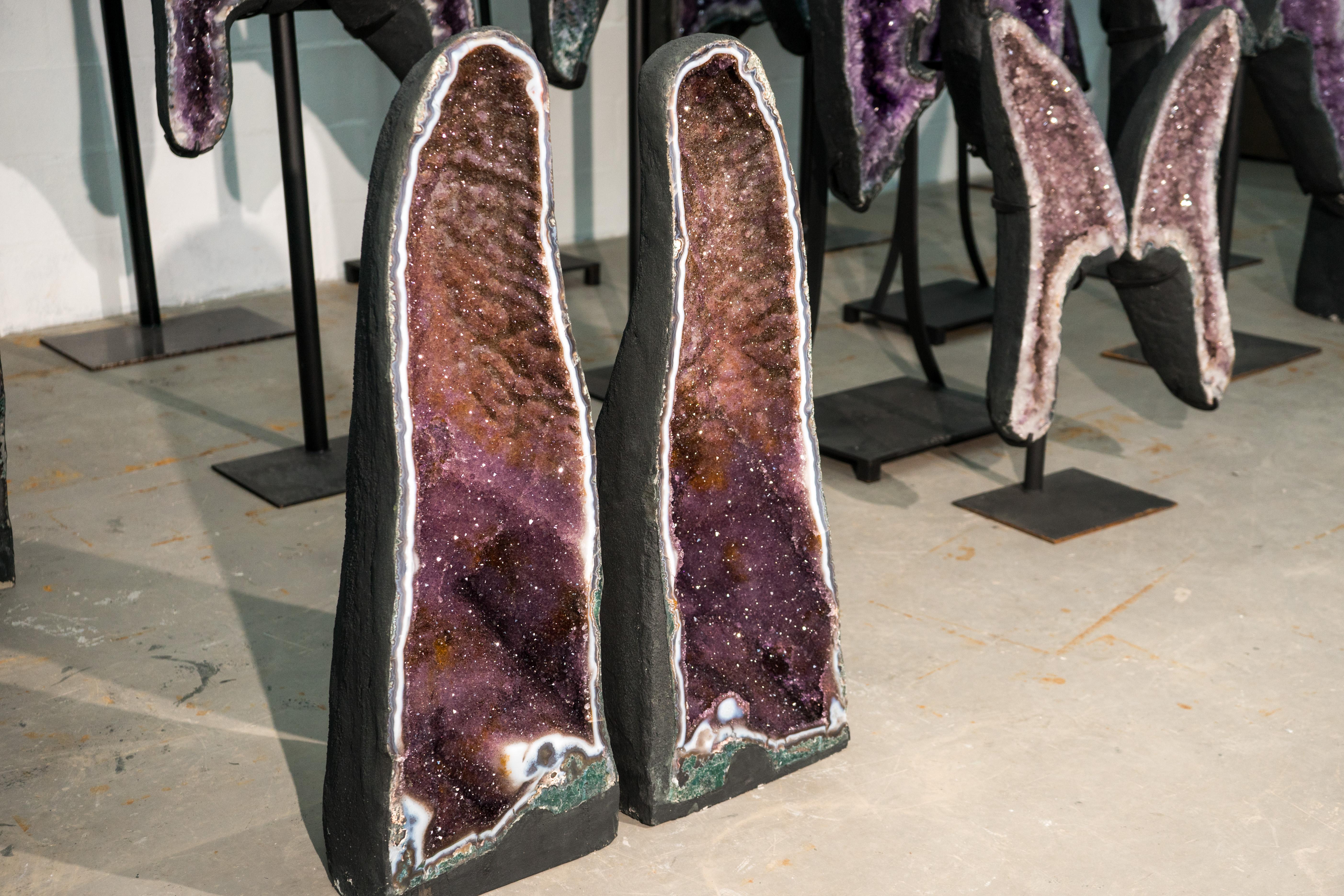 Seltenes Paar großer Amethyst-Kathedralgeoden mit funkelndem Galaxy-Druzy und Achat-Spitzenrahmen

▫️ Beschreibung

Dieses seltene und wunderschöne Paar von Amethyst-Geoden stellt eine ästhetische Formation dar, die vollständig mit funkelndem