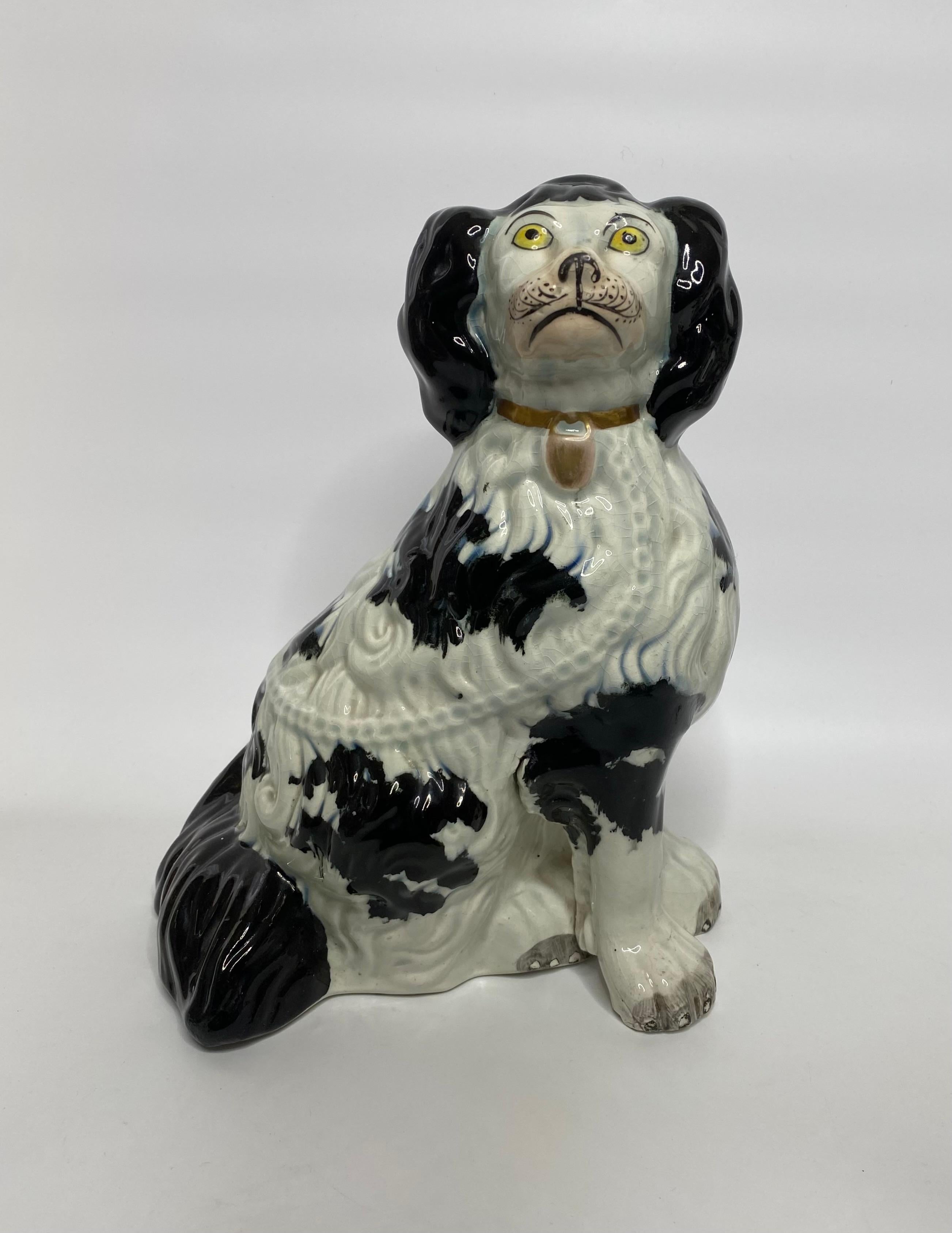 A fine, large pair of Staffordshire pottery Spaniels, c.1840. Both seated dogs, with separate front legs, and broad backsides. Finely moulded hair, and painted with underglaze black spots. Having yellow eyes, grey paws, pink muzzles, and wearing