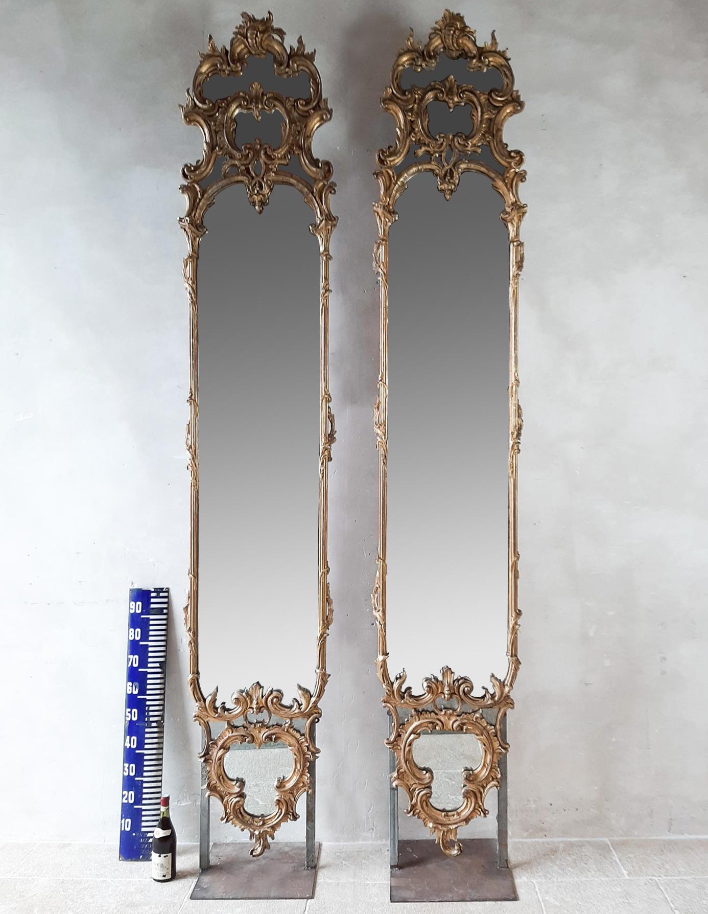 Pair of large antique french pier mirrors. The slim wooden frames are exceptionally rich and finely sculpted with goldleaf gilded gesso. The mirrors are abundantly ornamented. with on the top and bottom C-scrolls and leafs, and acanthus leafs around