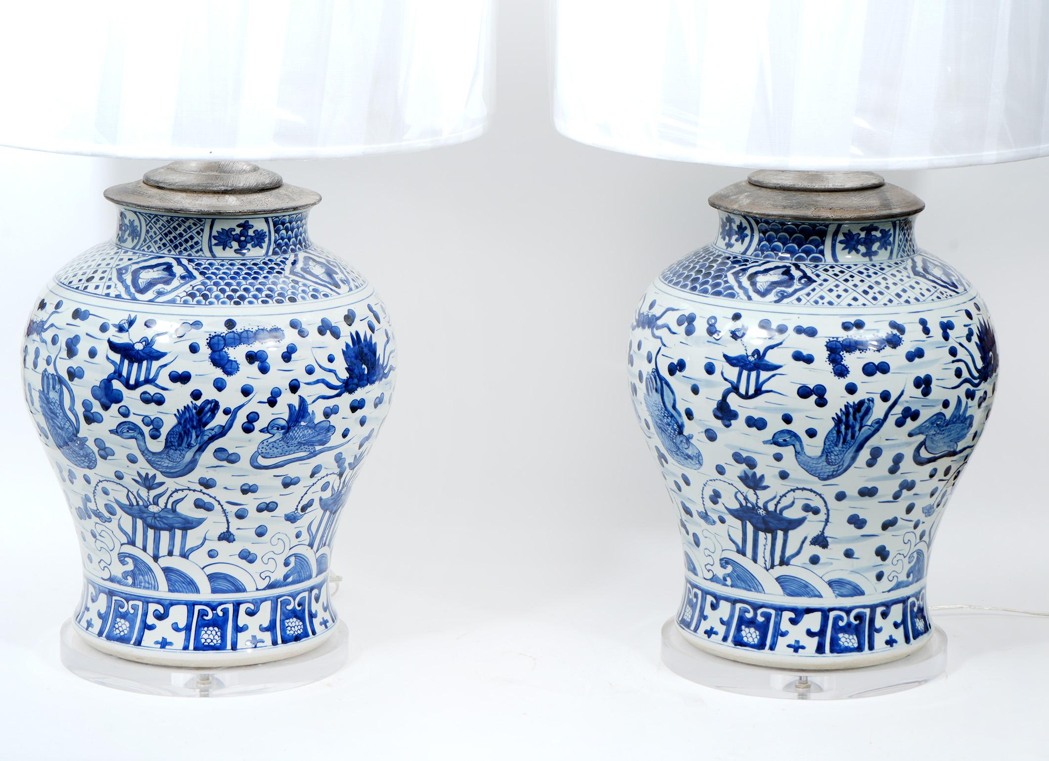 Large pair of large Chinese Blue and White porcelain lamps. Large antique vases mounted and made into lamps.  Lamps are newly rewired. Lucite is new. Shades are included. Overall 38