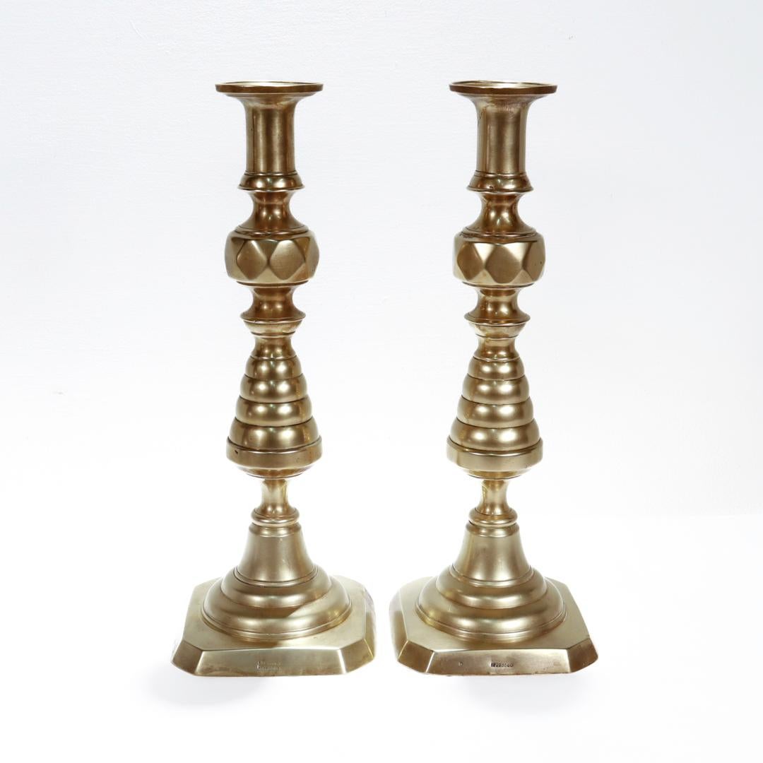 A fine pair of large antique English brass candlesticks.

In cast brass.

With stepped bases, pronounced beehive turnings, and faceted knops. 

Each marked to the base with an English Registry no. 223580

Simply a wonderful pair of classic antique