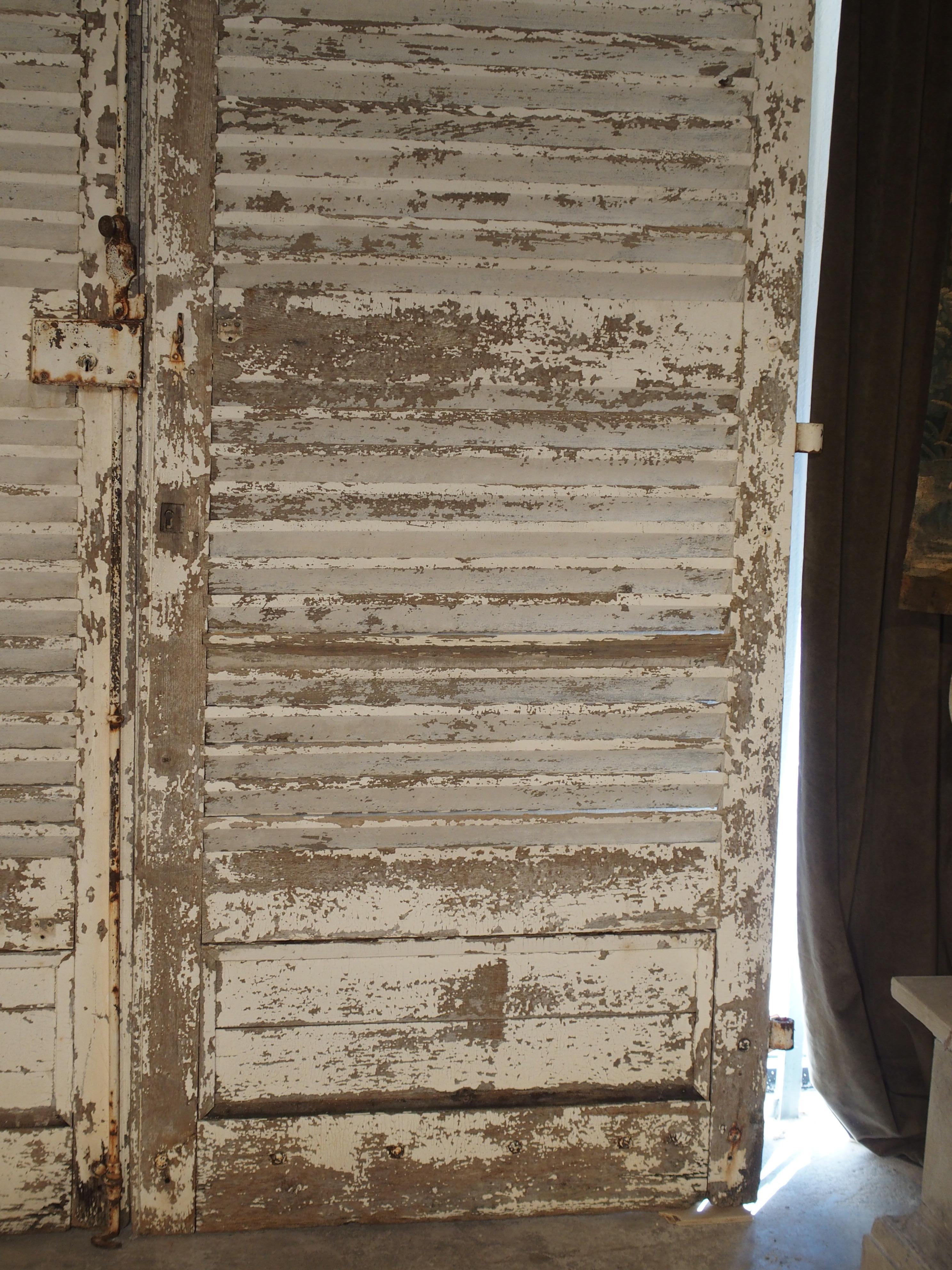 Ces volets anciens monumentaux en forme d'arc ont été récupérés dans un château français du XIXe siècle. Elles se trouvaient au rez-de-chaussée, attachées au bâtiment, et s'ouvraient en pivotant pour révéler des portes françaises en verre derrière.