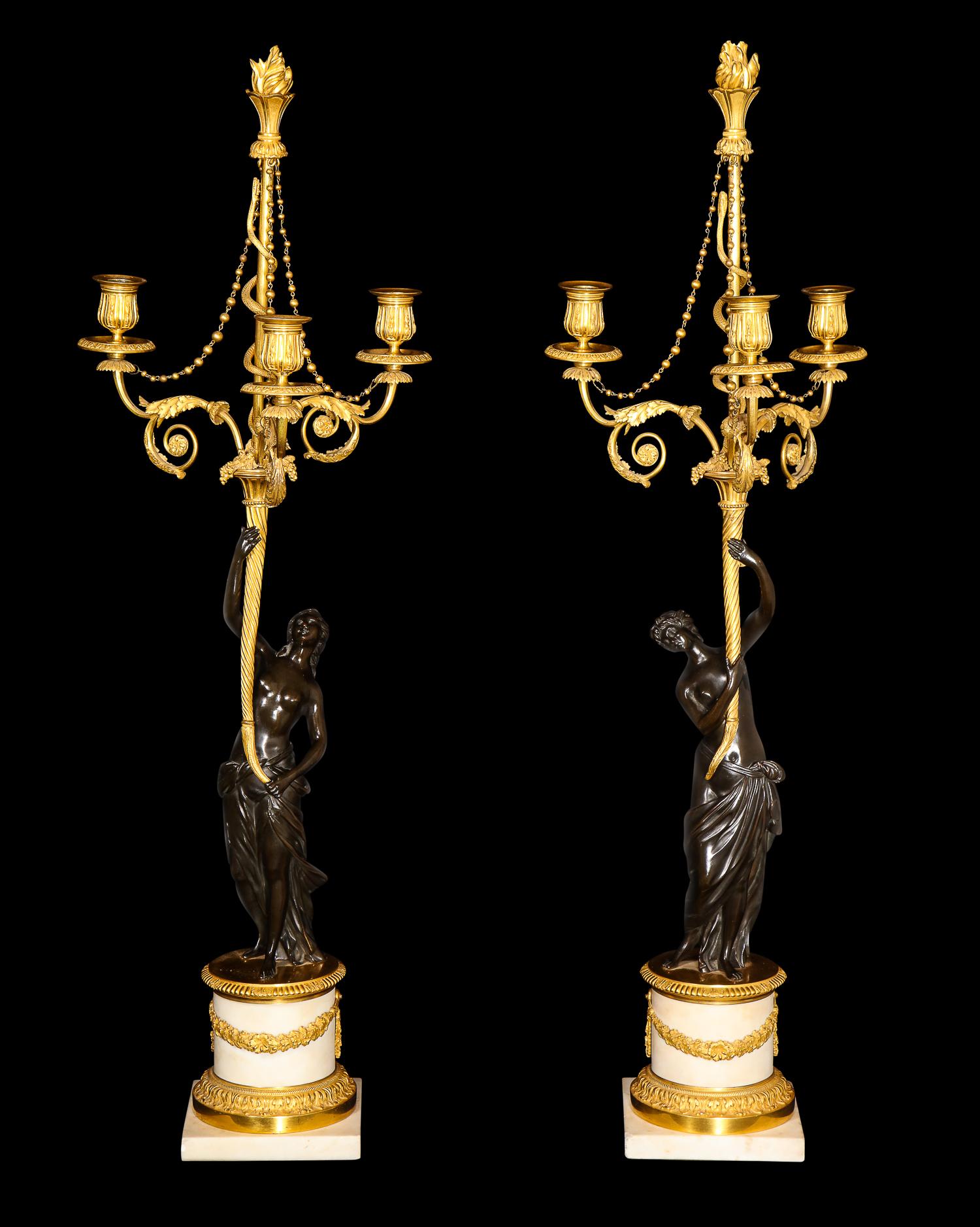A pair of magnificent large antique French Louis XVI Figural three-arm gilt bronze, patina bronze and white marble candelabras of superb quality embellished with patinated bronze figures of neoclassical ladies rested on white gilt bronze mounted