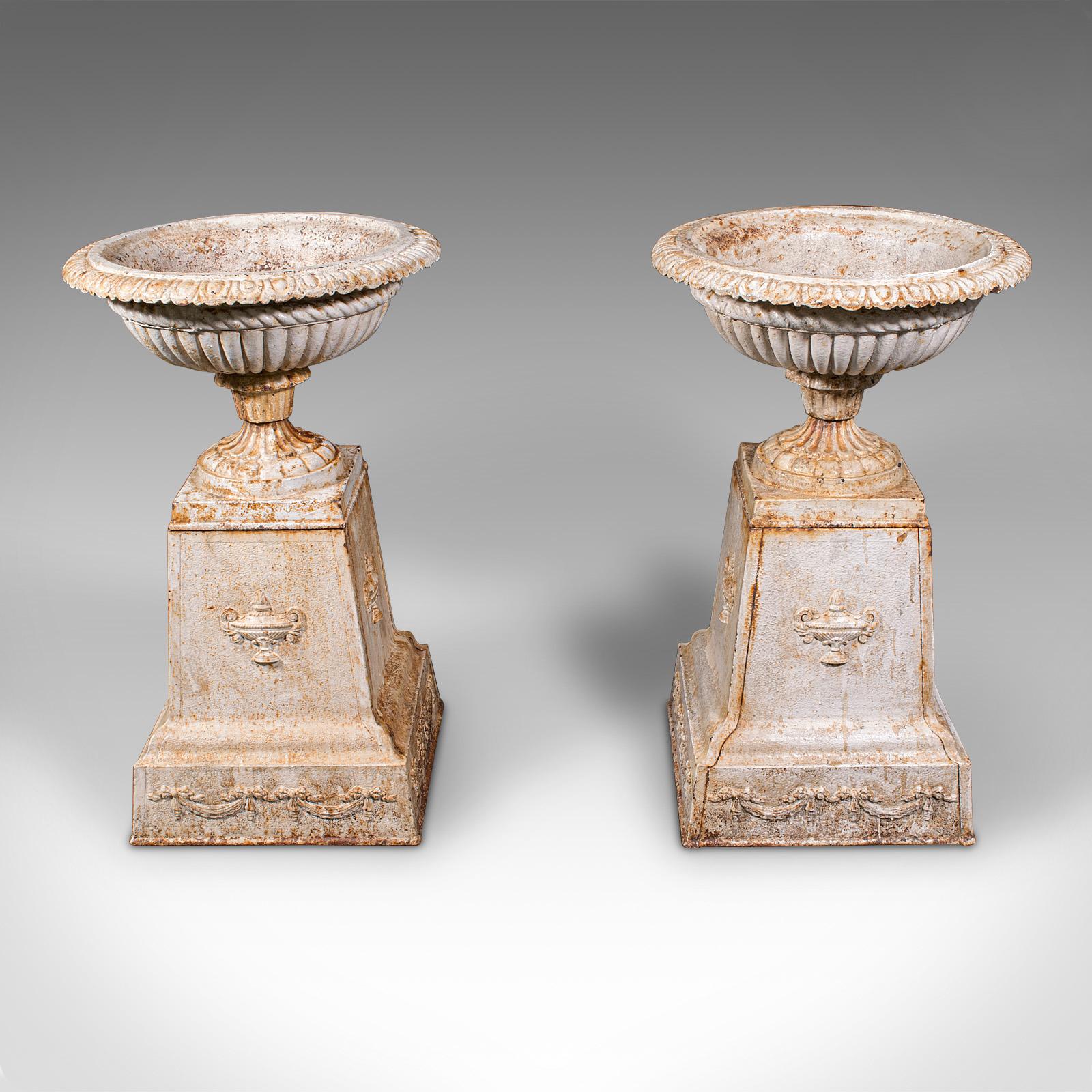 This is a pair of large antique garden planters. An English, cast iron planting bowl on pedestal base, dating to the late Victorian period, circa 1880. A delightfully rare and decorative set of substantial outdoor jardinières, with enduring