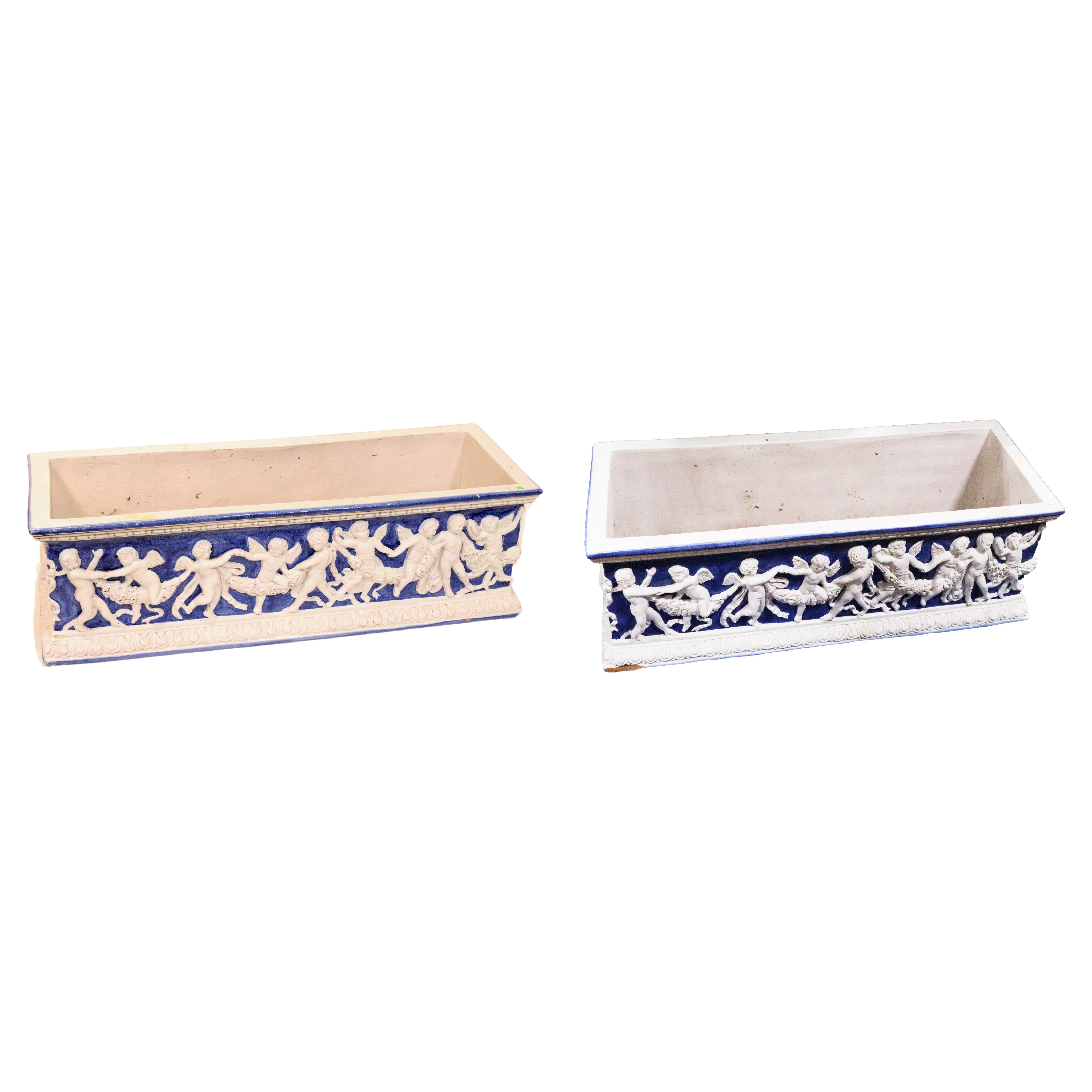 Pair of antique Majolica planters, in a large scale size in blue and white decorated with putti and draping garlands. These planters were part of a Gentleman's Majolica collection amassed over 40 years in Europe.  These Italian Majolica planters are