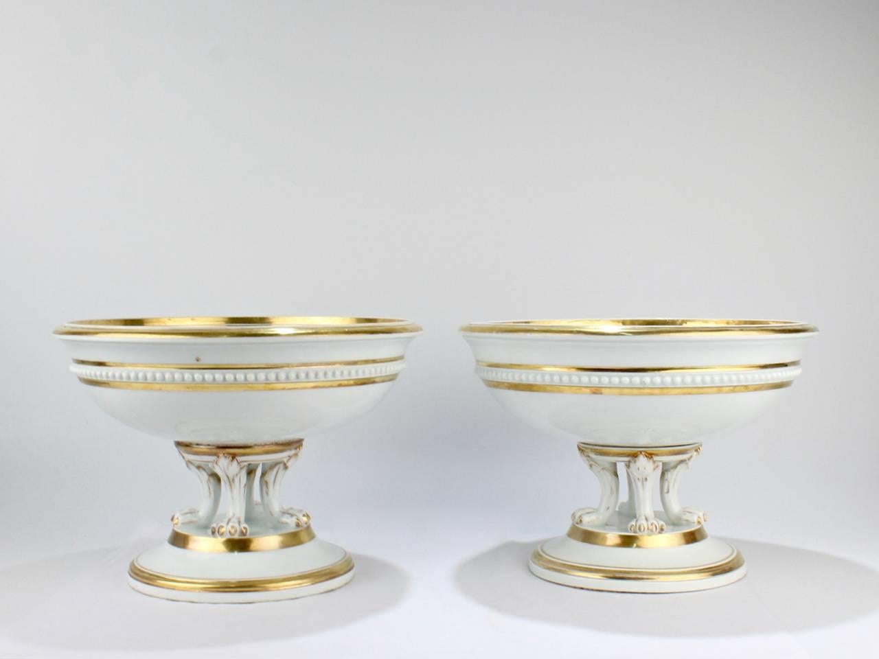 A rare and wonderful pair of antique Meissen porcelain topographical tazzas or footed bowls.

Each bowl has a central hand-painted scene, a wide band of gilding to the rim, and beading to the girth. Each is supported by claw feet and a plunger base.