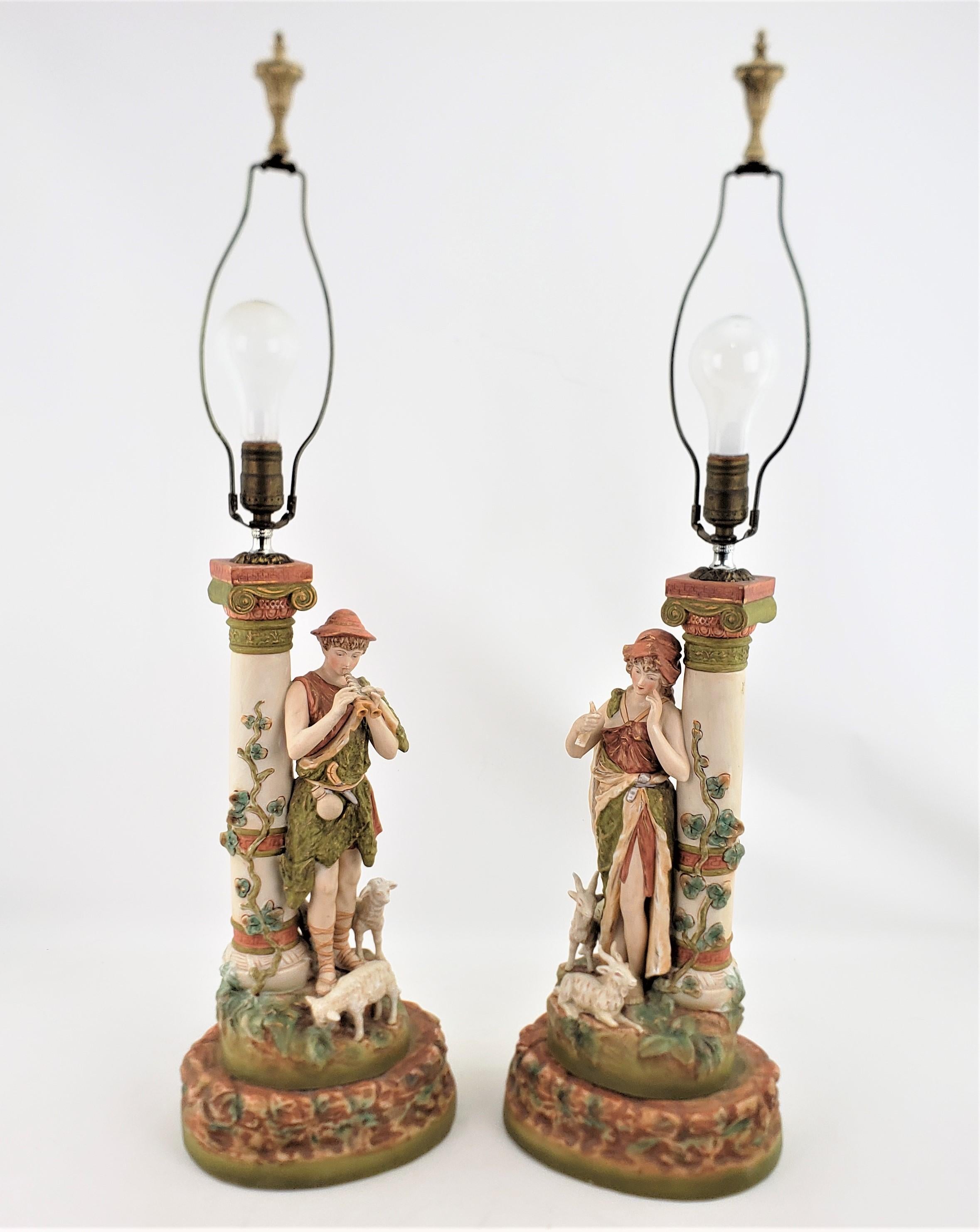 This large pair of antique porcelain lamps are unsigned, but being attributed to the Royal Dux factory of Bohemia, now the Czech Republic, in a Neoclassical Revival style. The detailed modelling and hand-painting we believe are highly consistent
