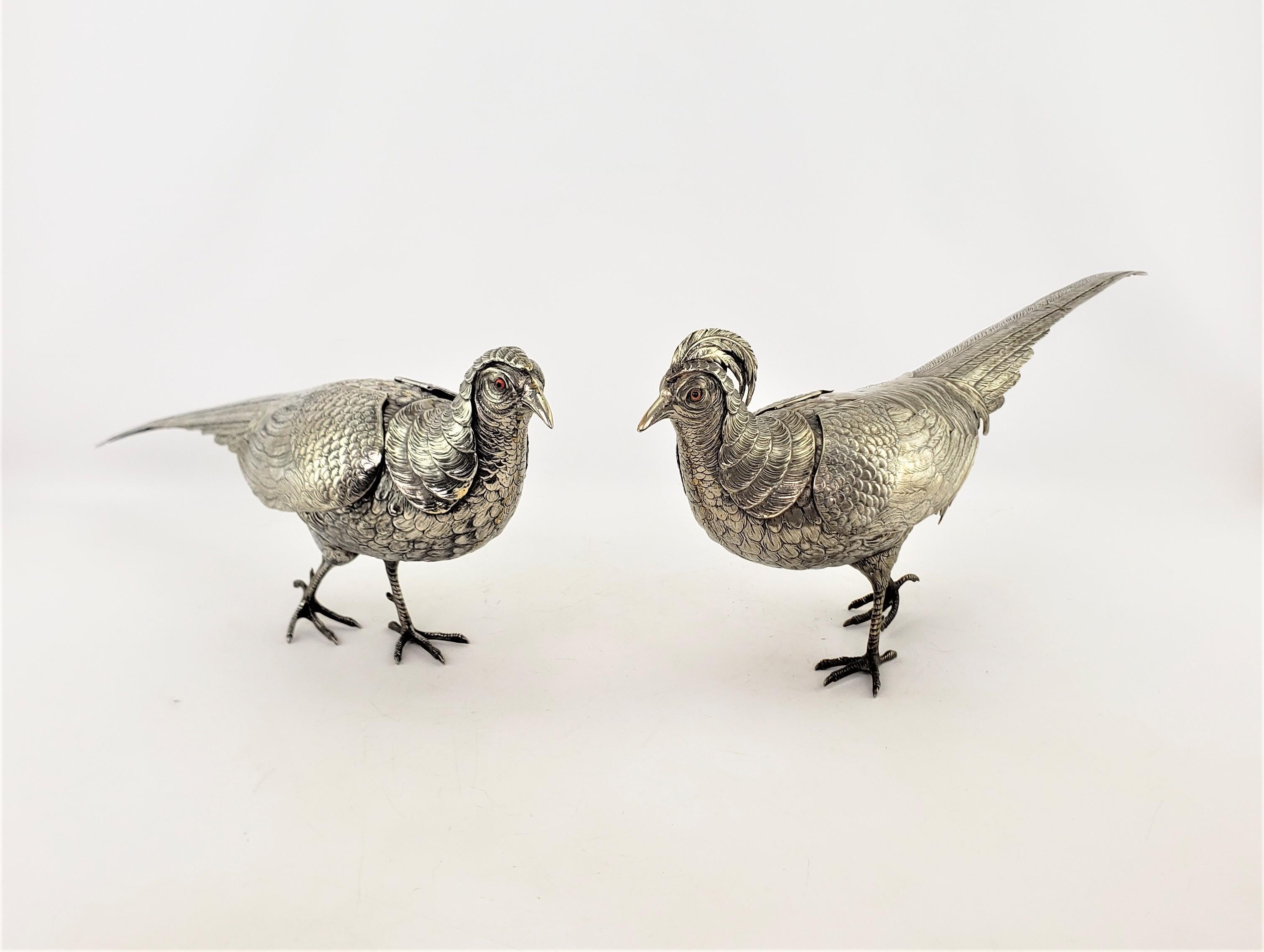 This pair of large antique exotic bird or pheasant sculptures were done by artist G. Vivaldi of Italy in approximately 1920 in a Victorian style. The sculptures are composed of silver plate over copper and depict a pair of detailed walking pheasants