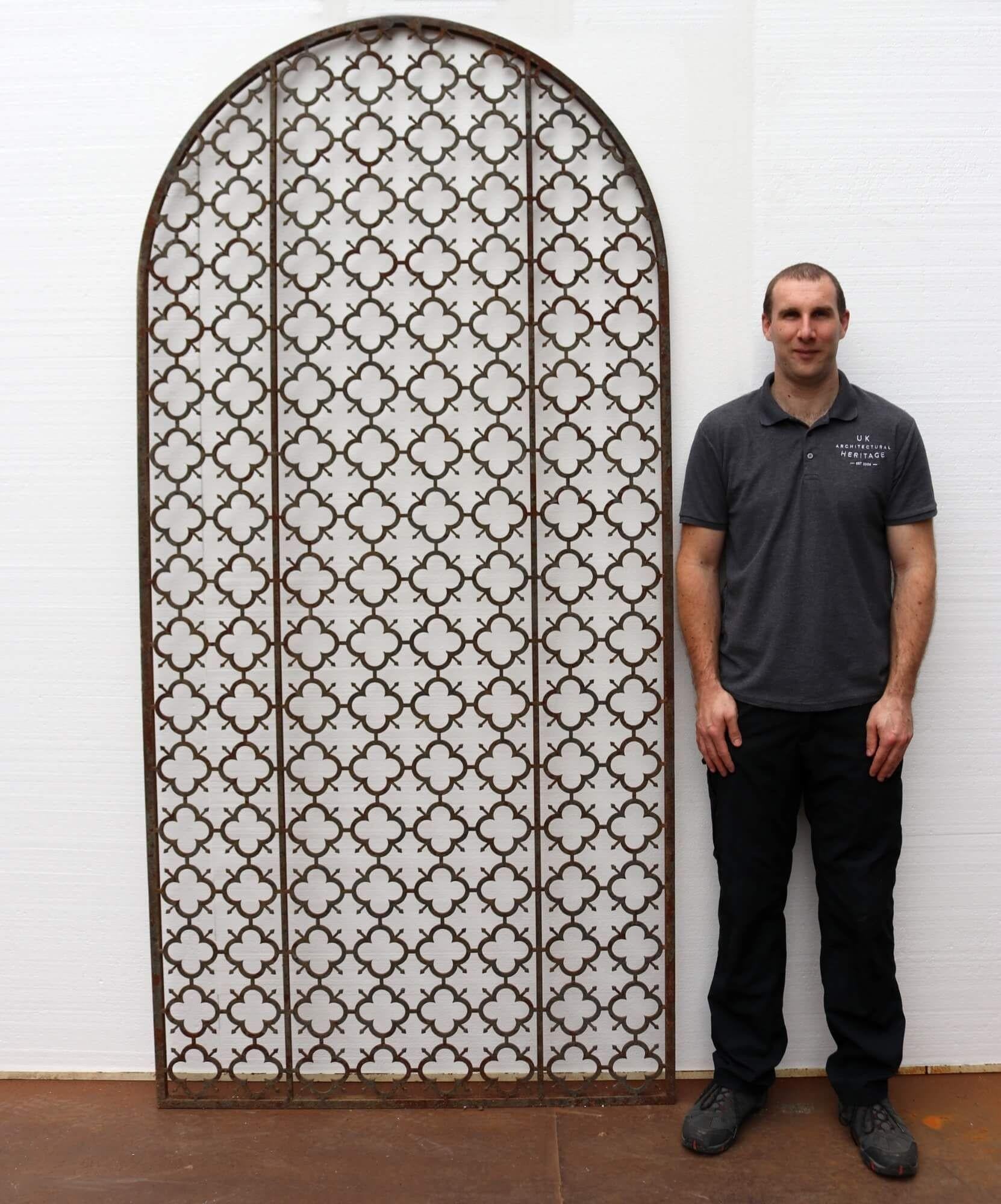 A pair of large arched metal panels, crafted in steel with a repeated quatrefoil pattern. This striking pair could be used as fixed panels within a garden scheme as decorative garden trellis panels or metal garden screens, making a distinguished