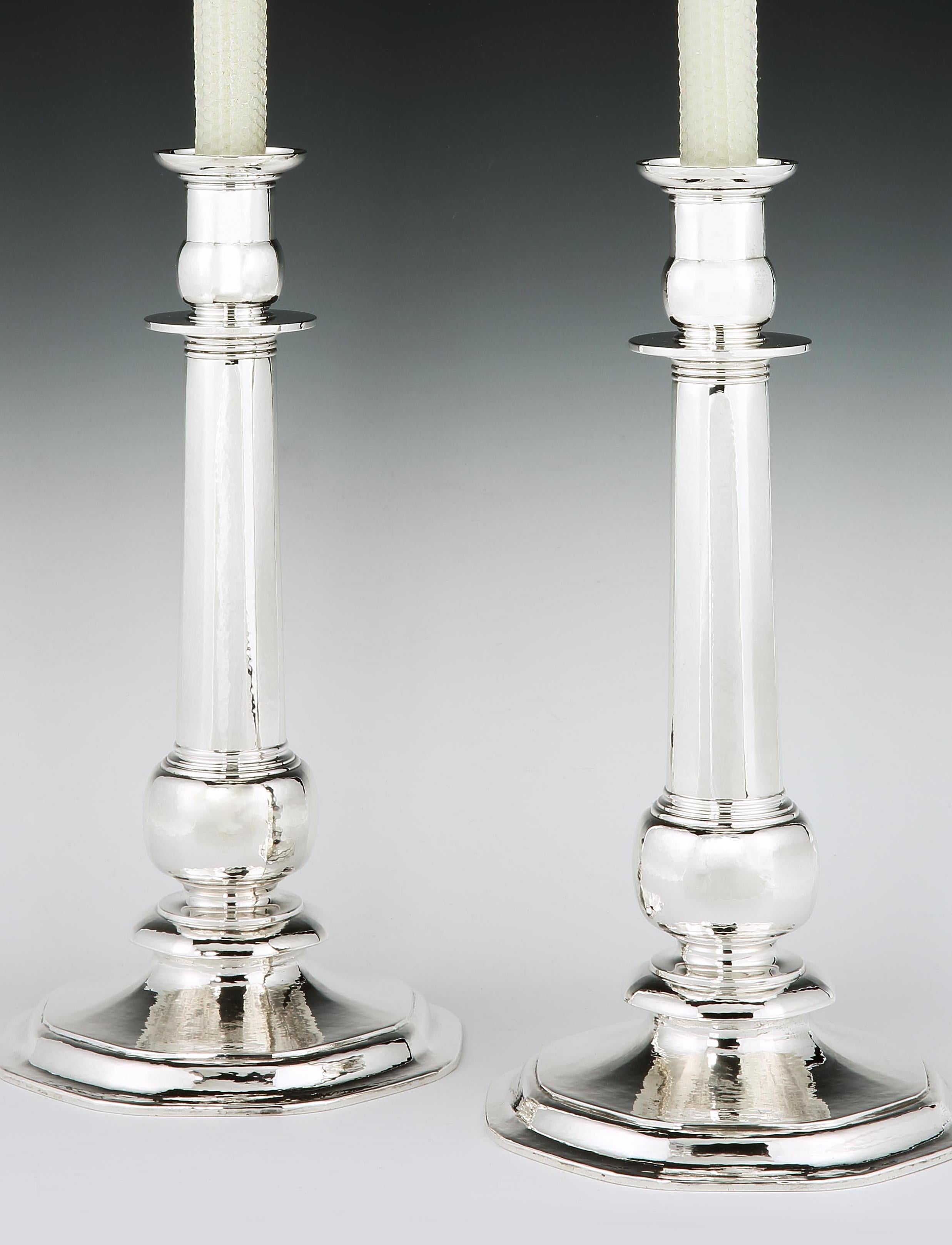 A pair of spectacular and large sterling silver candlesticks each with a hammered or martele finish, and designed in a classical style with a broad swept circular base with Art Deco monogram of LSB engraved to the base of each stick. The pair were