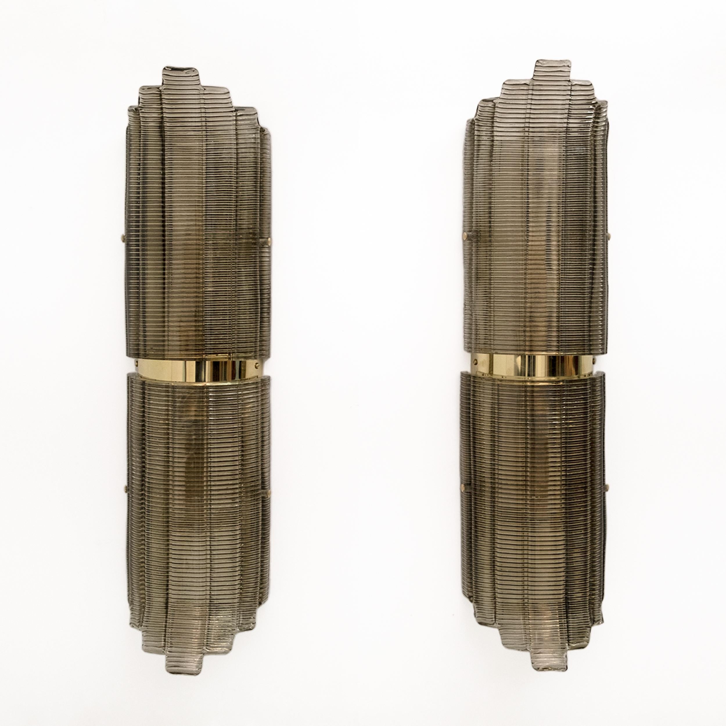 Pareja de apliques de cristal de Murano color humo, de cristal estructurado y latón. El cristal está texturizado con nervaduras y tiene un diseño curvado, que crea un magnífico impacto decorativo. Cada aplique requiere una bombilla de casquillo