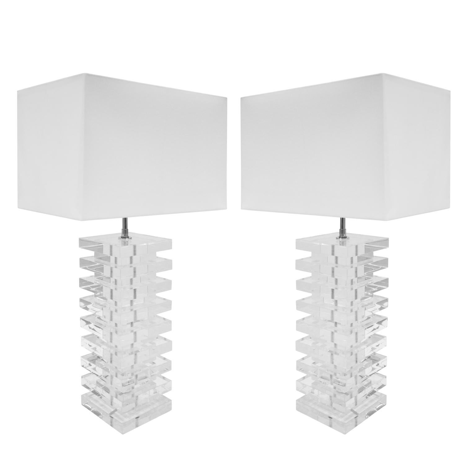 Artisan large pair of table lamps in stacked slabs of solid lucite with chrome fittings, sockets and silk cord. American, 1970's.  These lamps have a nice scale.  Lucite been professionally cleaned and polished.  It is perfectly clear.  Chrome has