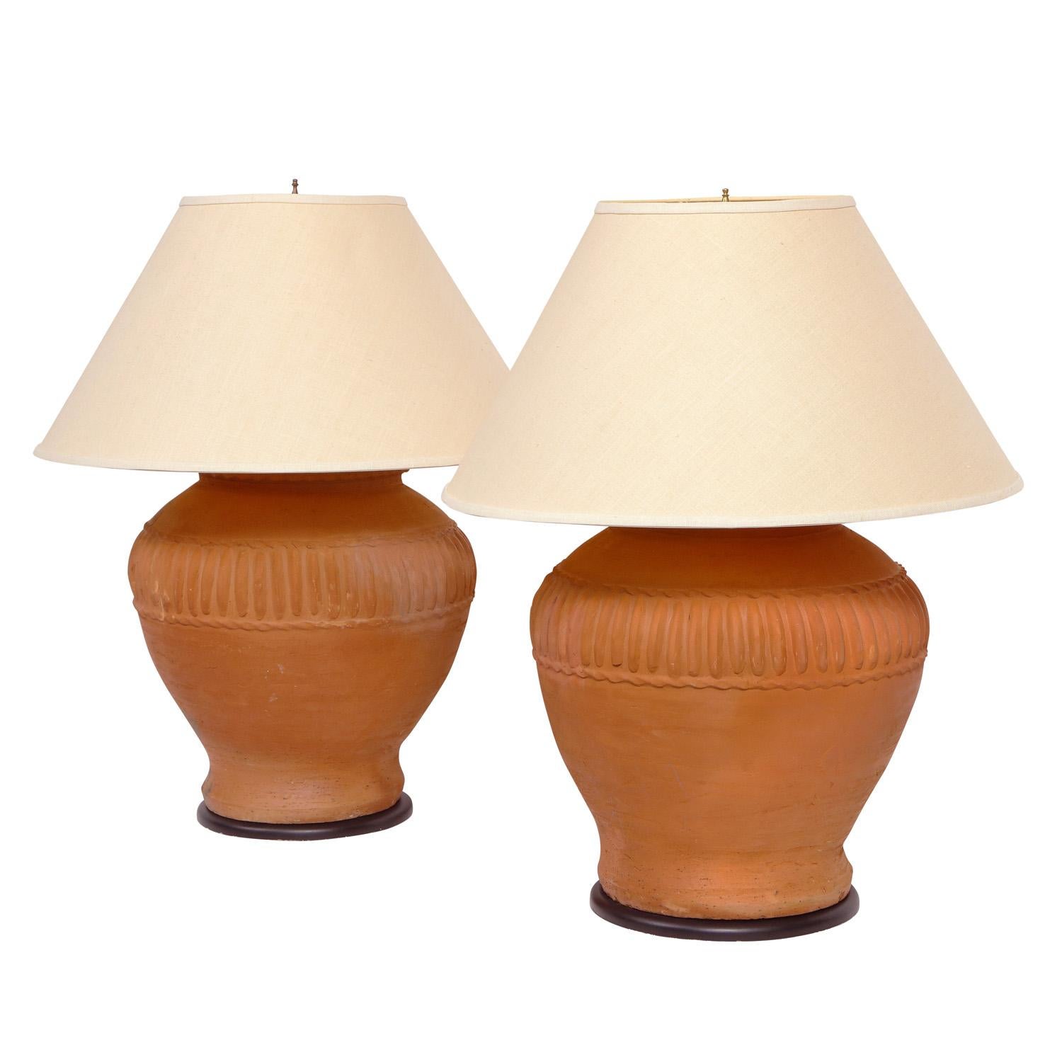 Pair of large artisan made terracotta table lamps, American 1970's. It is rare to see terra cotta lamps in this quality and scale. These came from a published 1970’s interior.
