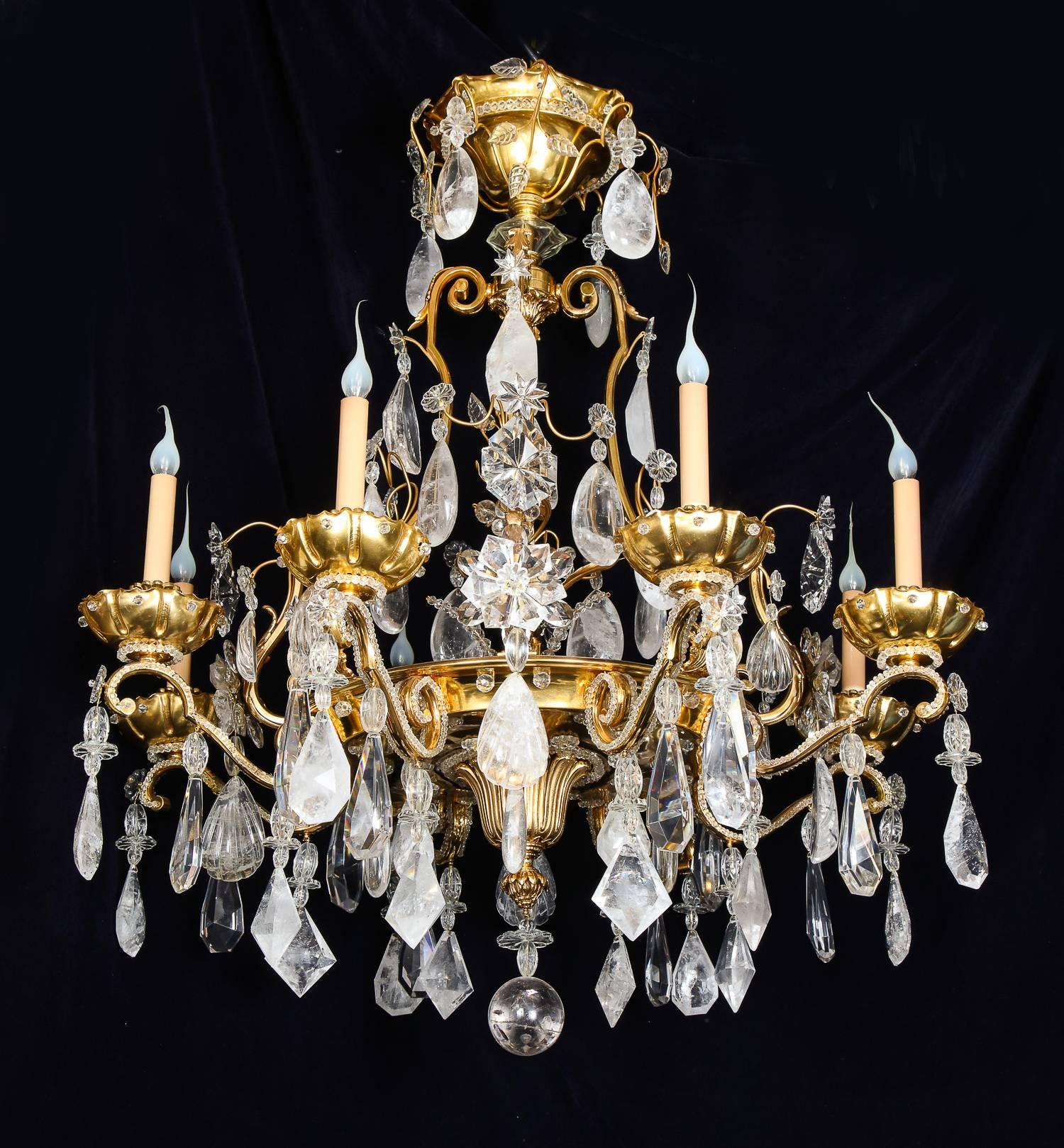A pair of large and spectacular antique French Baguès Louis XVI style gilt bronze, cut rock crystal, crystal and beaded glass multi light chandeliers of superb craftsmanship embellished with fine cut rock crystal prisms, rock crystal flowers,