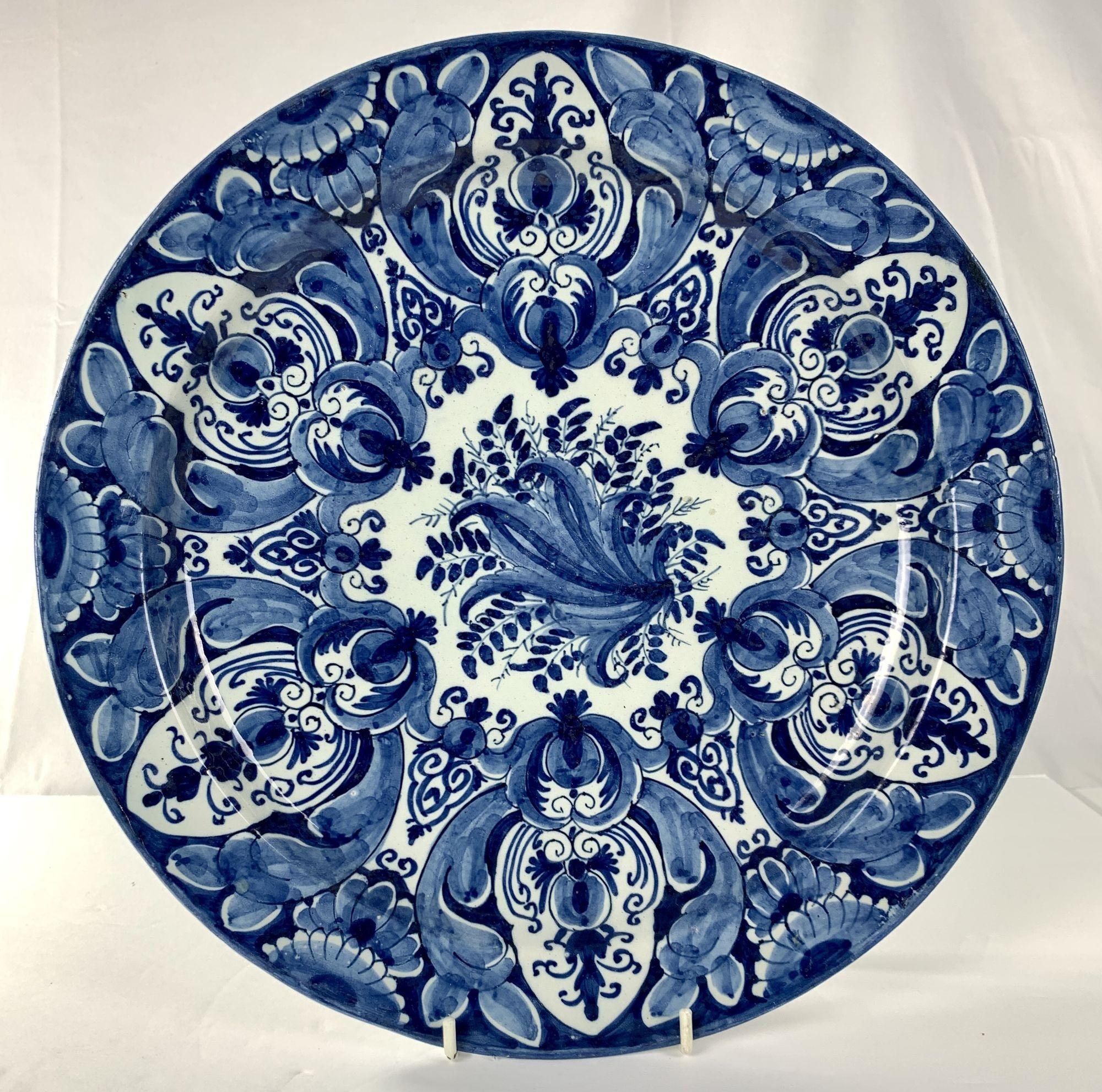 This pair of blue and white Delft chargers were made at De Metalen Pot in the Early 18th century circa 1710.
The chargers were hand-painted in deep cobalt blue.
We see an eye-catching, symmetrical floral pattern with flowers, budding flowers, and