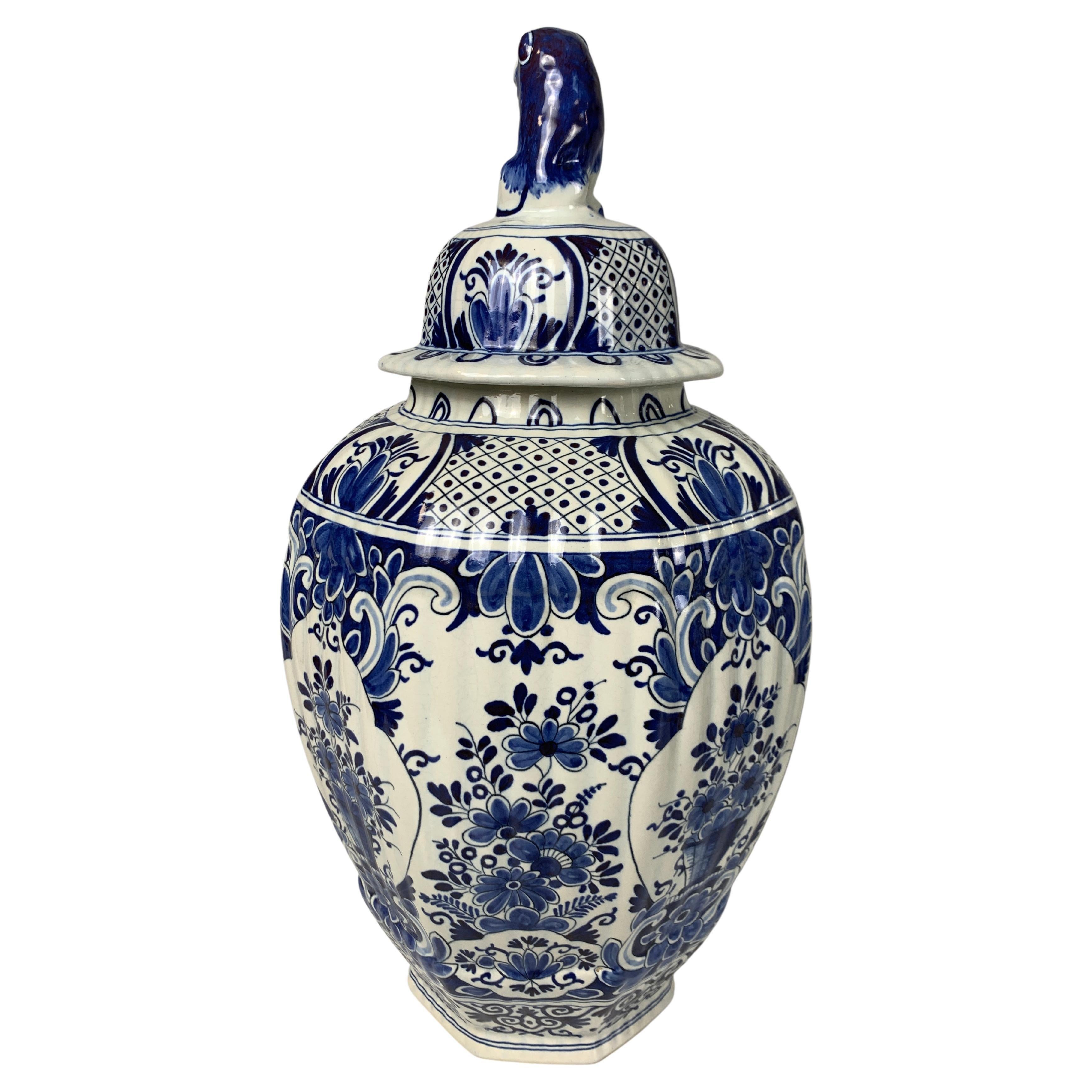 This pair of large Delft jars has a traditional blue flower decoration painted on a white tin-glaze ground. 
Each jar is painted, showing beautiful flowers.
The shoulders and cover were also decorated in a traditional style with floral panels