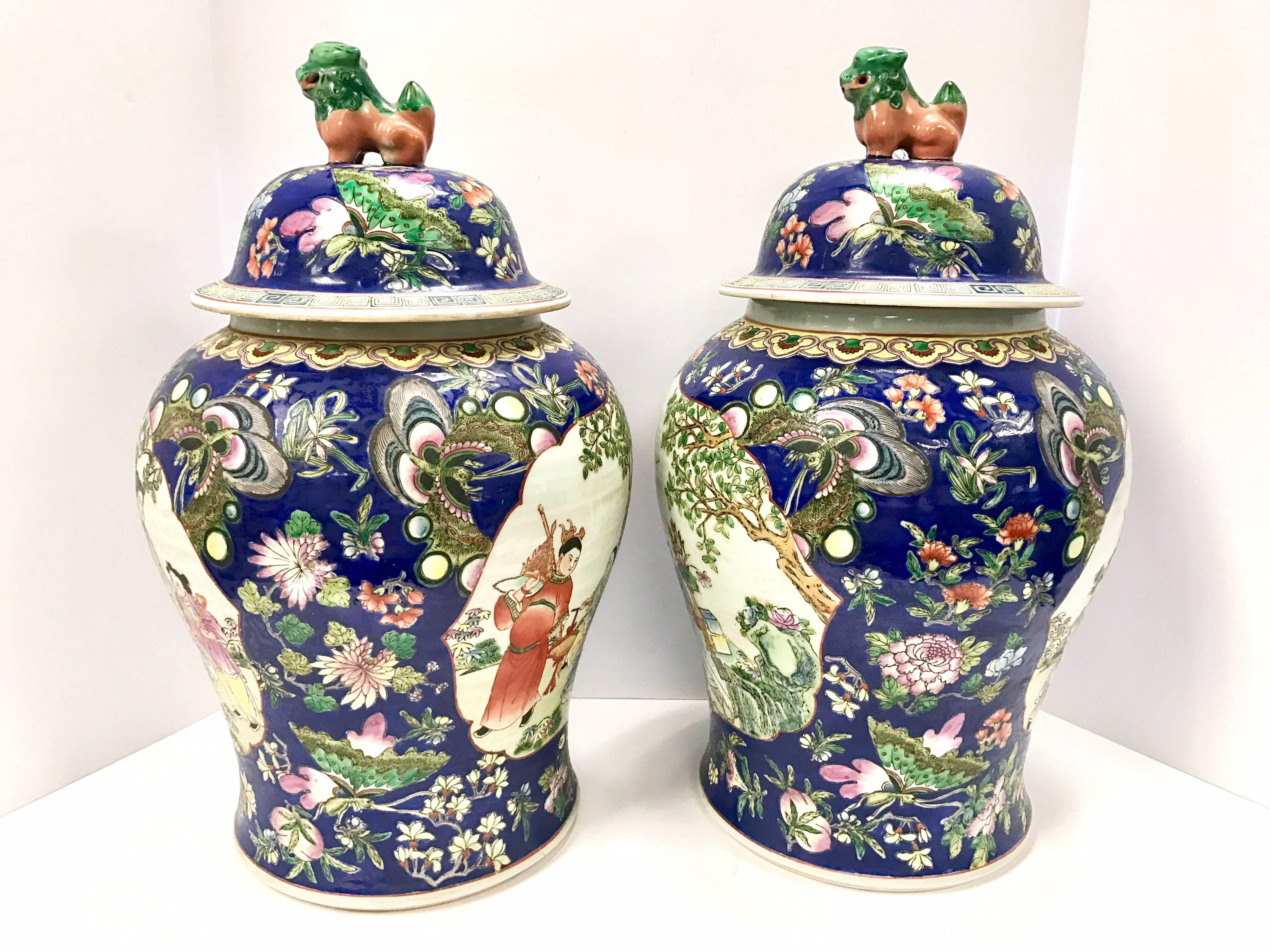 Elegant pair of large blue Chinese urns with foo dogs and vibrant colors.