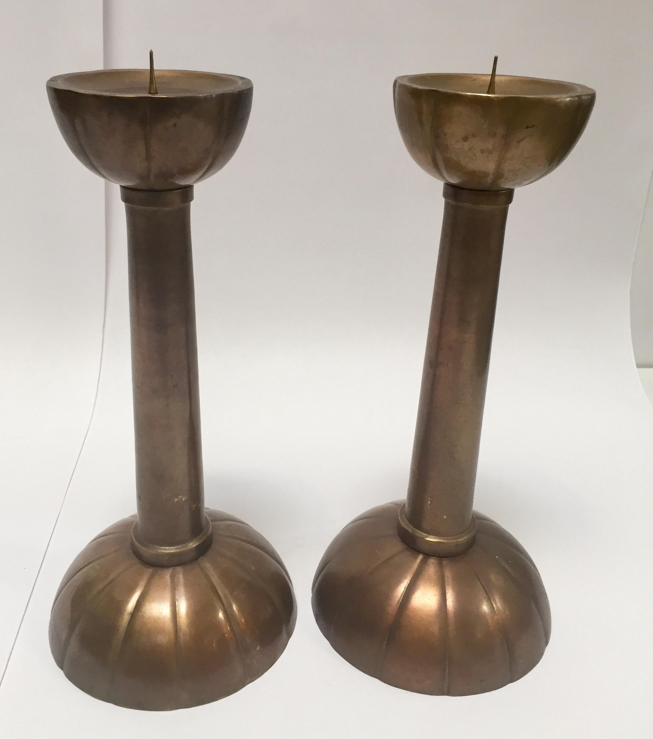 Fabulous pair of large brass candlesticks on a round scalloped base.
Tall form with scalloped base and upper part underneath of the candle prong.
They are a true beauty and will fit any environment.
Cast iron brass, rose color, nice patina.
Mid 20th