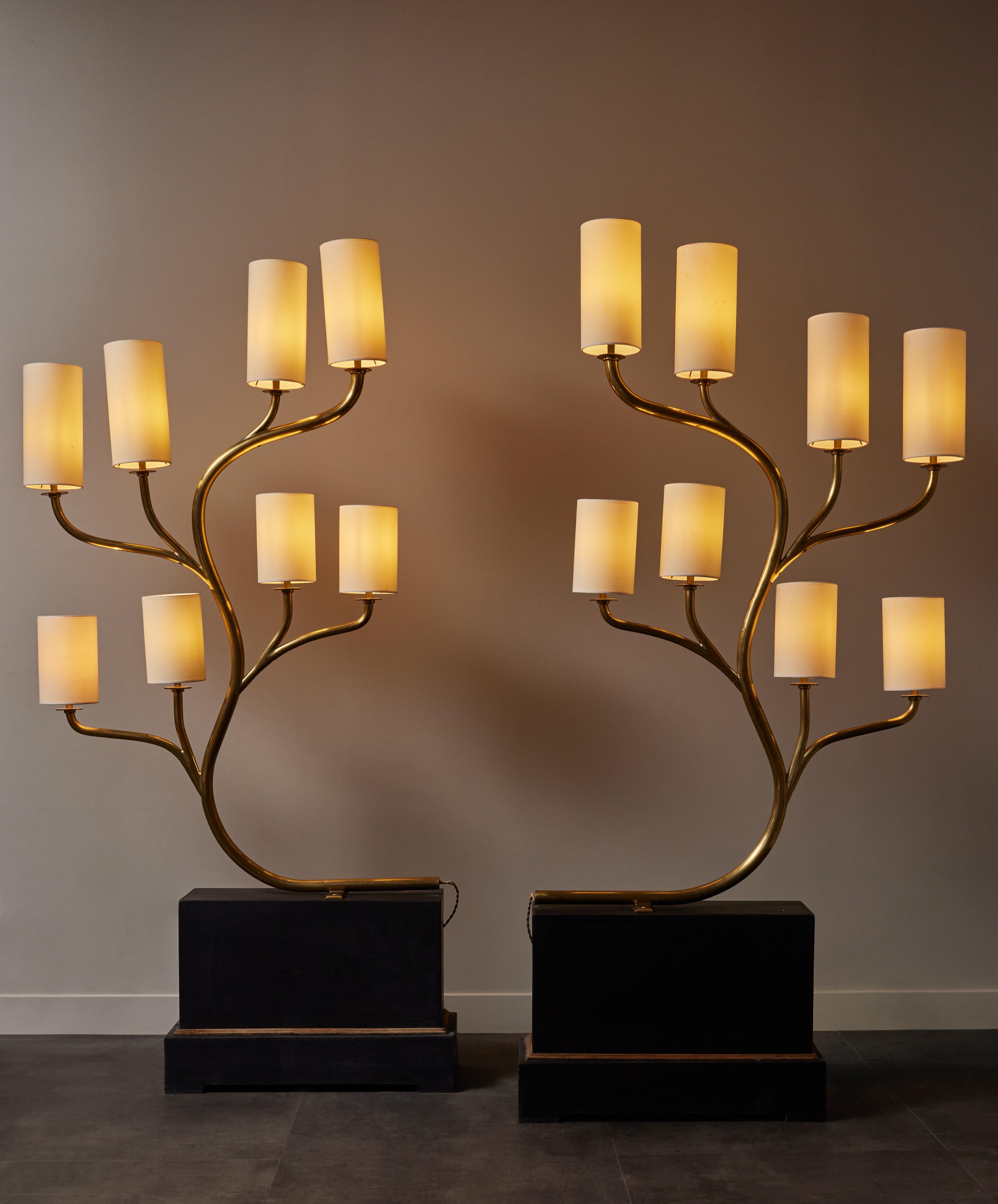 Pair of impressive floor lamps, ideal against a wall or as room dividers.

Rectangular wood base, on which is attached a brass tree with eight arms of lights, each topped with a coton shade.