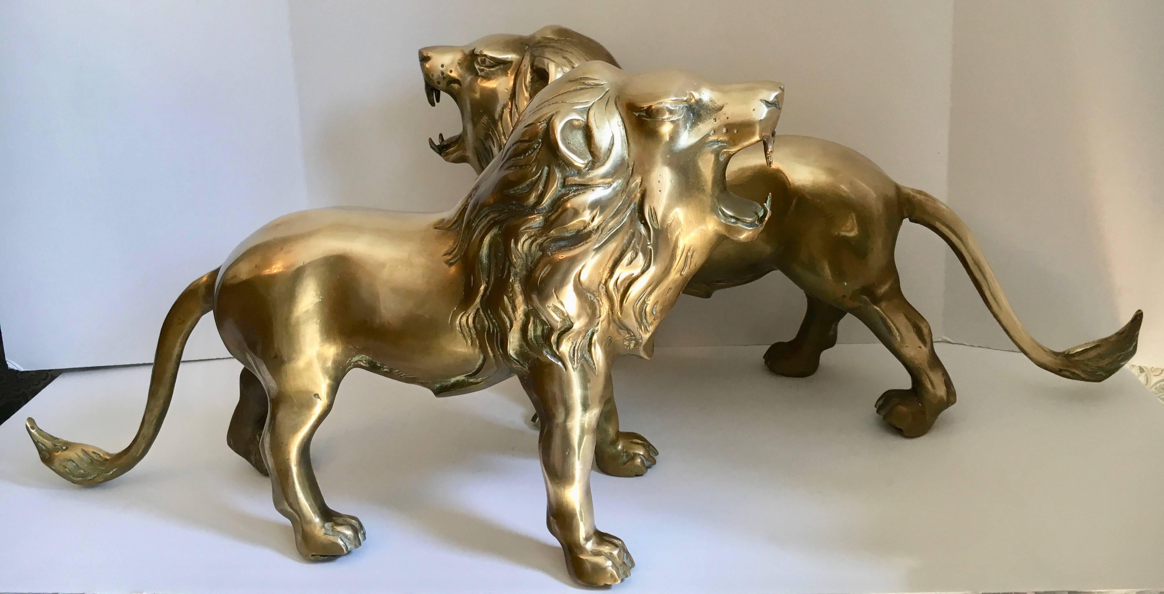 Pair of large brass lions. A very handsome pair of brass lions. The dominant and ferocious pair is large enough to hold a larger set of books in your library or shelf. As a decorative pair they can easily flank the mantle, table or shelf.