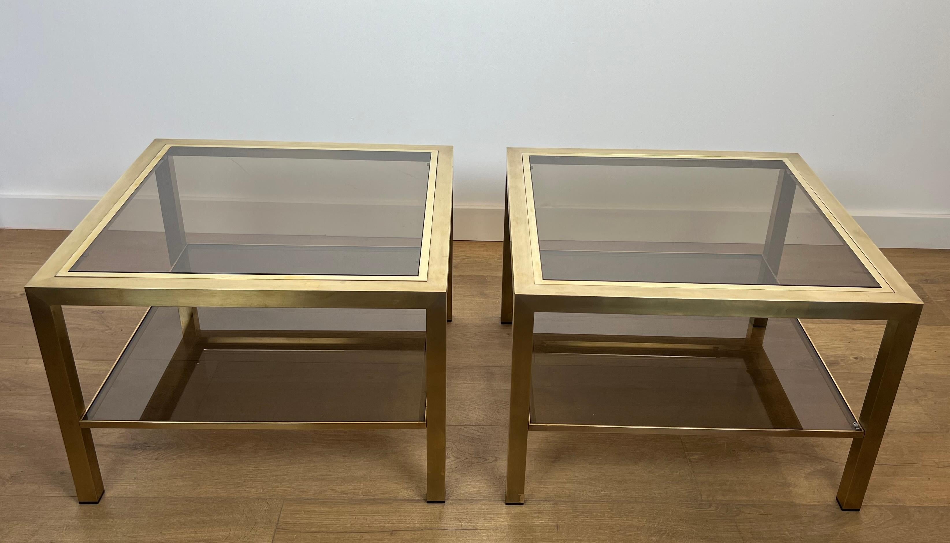 Cette belle et grande paire de tables d'appoint est fabriquée en laiton avec du verre fumé. Il s'agit d'un ouvrage français. Circa 1970