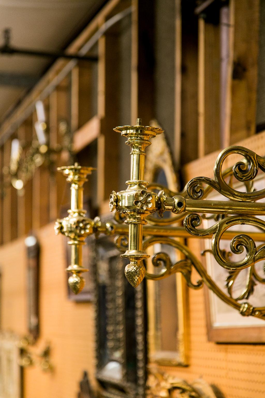 This pair of large brass French wall sconces have heavy cast brass support extensions that terminate in vertical lamp mounts. The support extensions are made with floral arabesques and have a flat back support with a stylized scallop shell at the