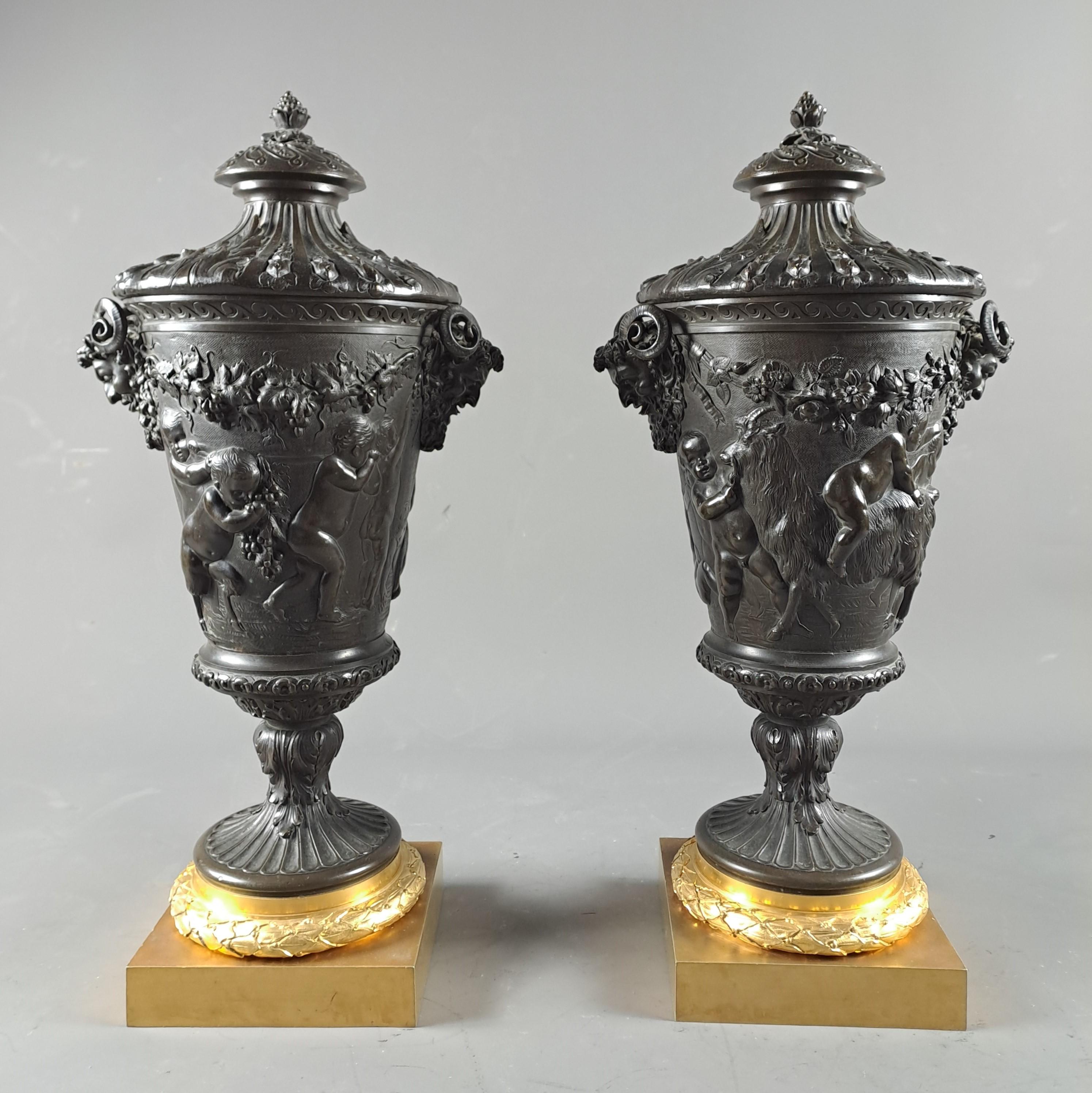 Exceptional pair of large covered vases in gilded bronze and brown patina presenting a rich bas relief decoration of neoclassical inspiration appearing in friezes of bacchanals of putti, satyrs, rams...
The handles are in the shape of a bearded
