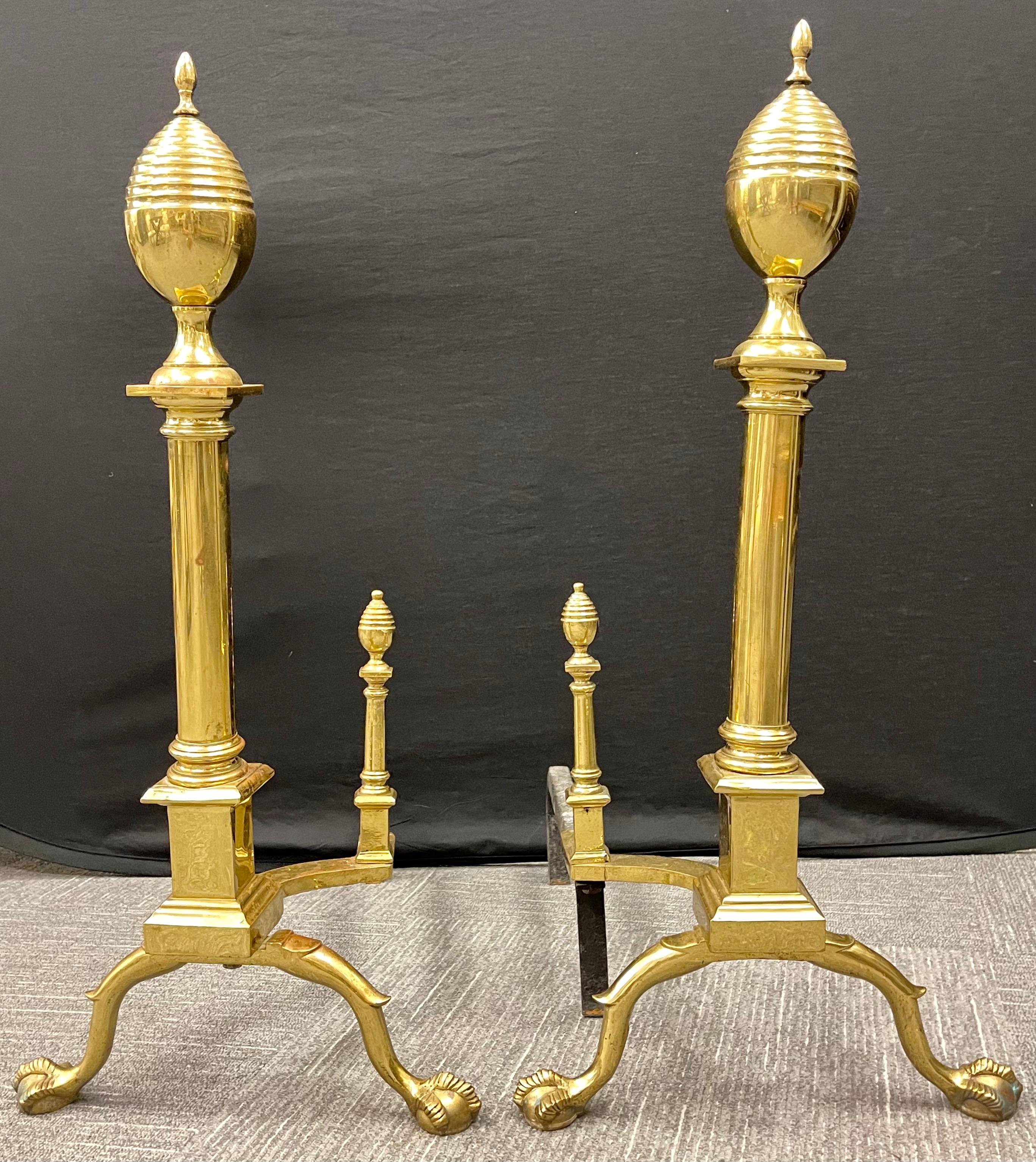 Pair of large Bronze Georgian style andirons. These large and impressive andirons have been polished and are ready to sit in front of any fireplace setting. Set on ball and hairy claw feet leading to column form center and terminating in a oval