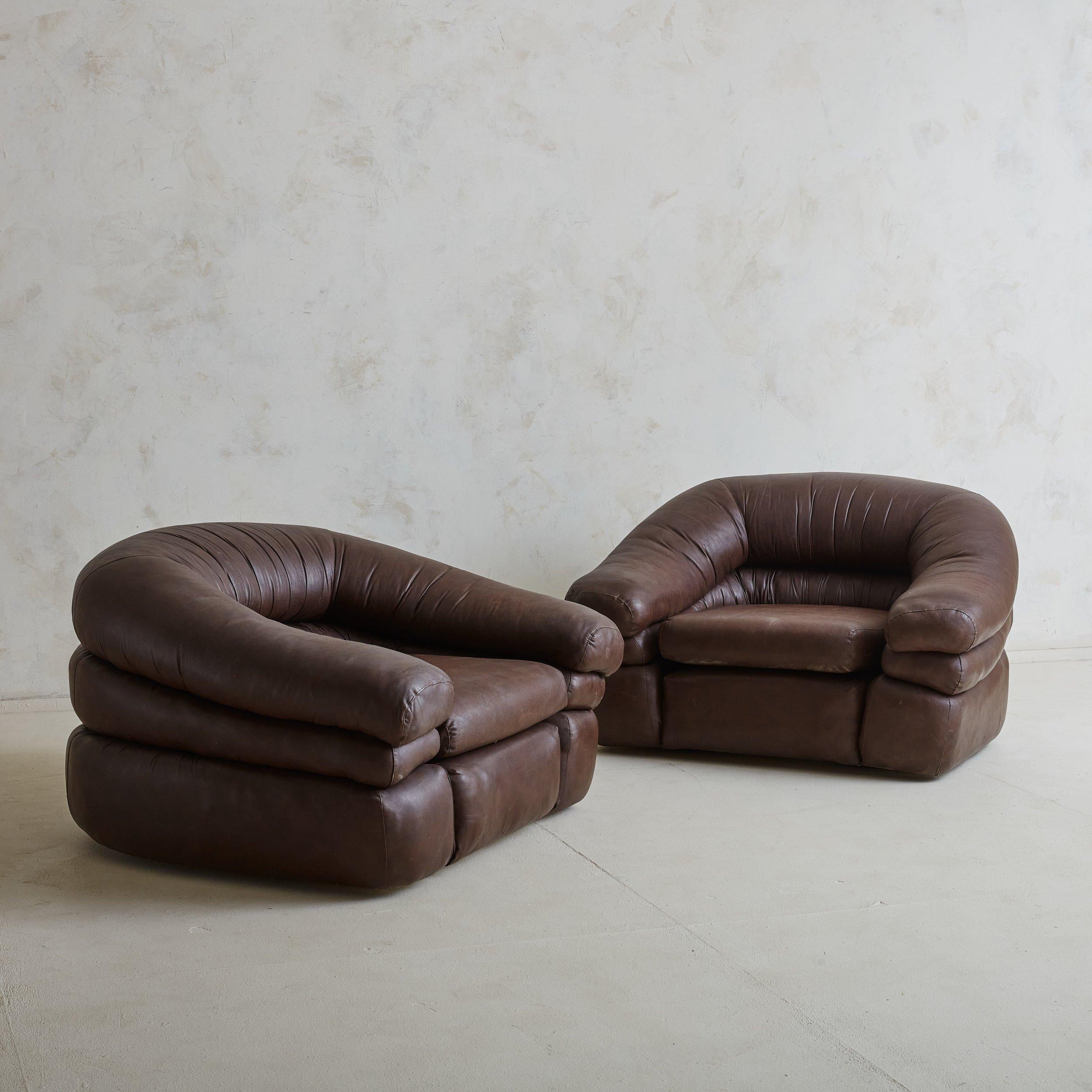 A pair of rare Italian patinated leather lounge chairs designed by Gionathan de Pas, Donato D’Urbino, and Paolo Lomazzi in the 1960s. These tub-form lounge chairs are entirely molded of foam and covered with original thick, soft leather in a rich