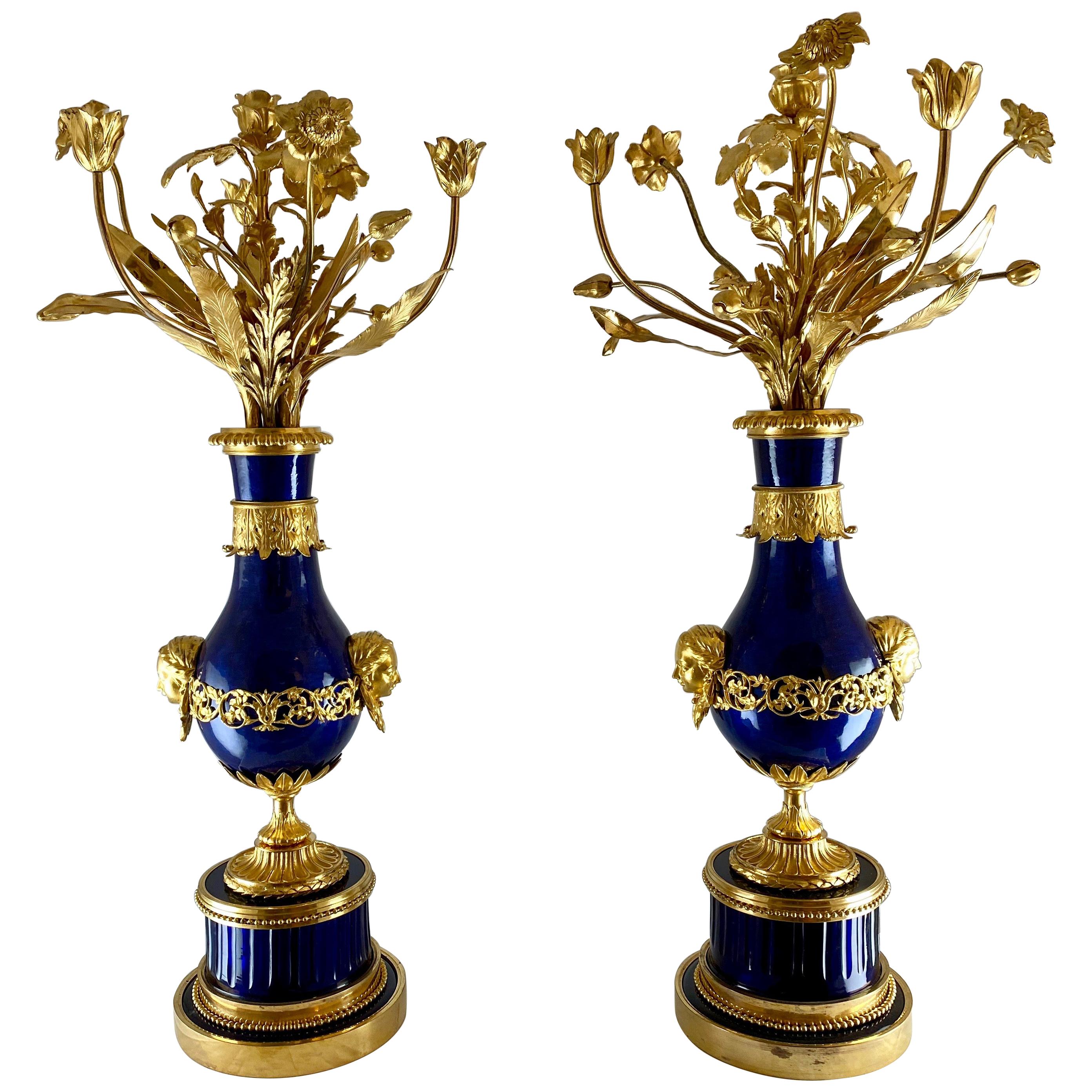 A fantastic pair of candelabra made in the late 18th century. The bases are made of thick coboltblue cut glass which is very unusual. The baluster shaped vases are made of silvered copper which are enammeled blue . The metal parts, which all are of