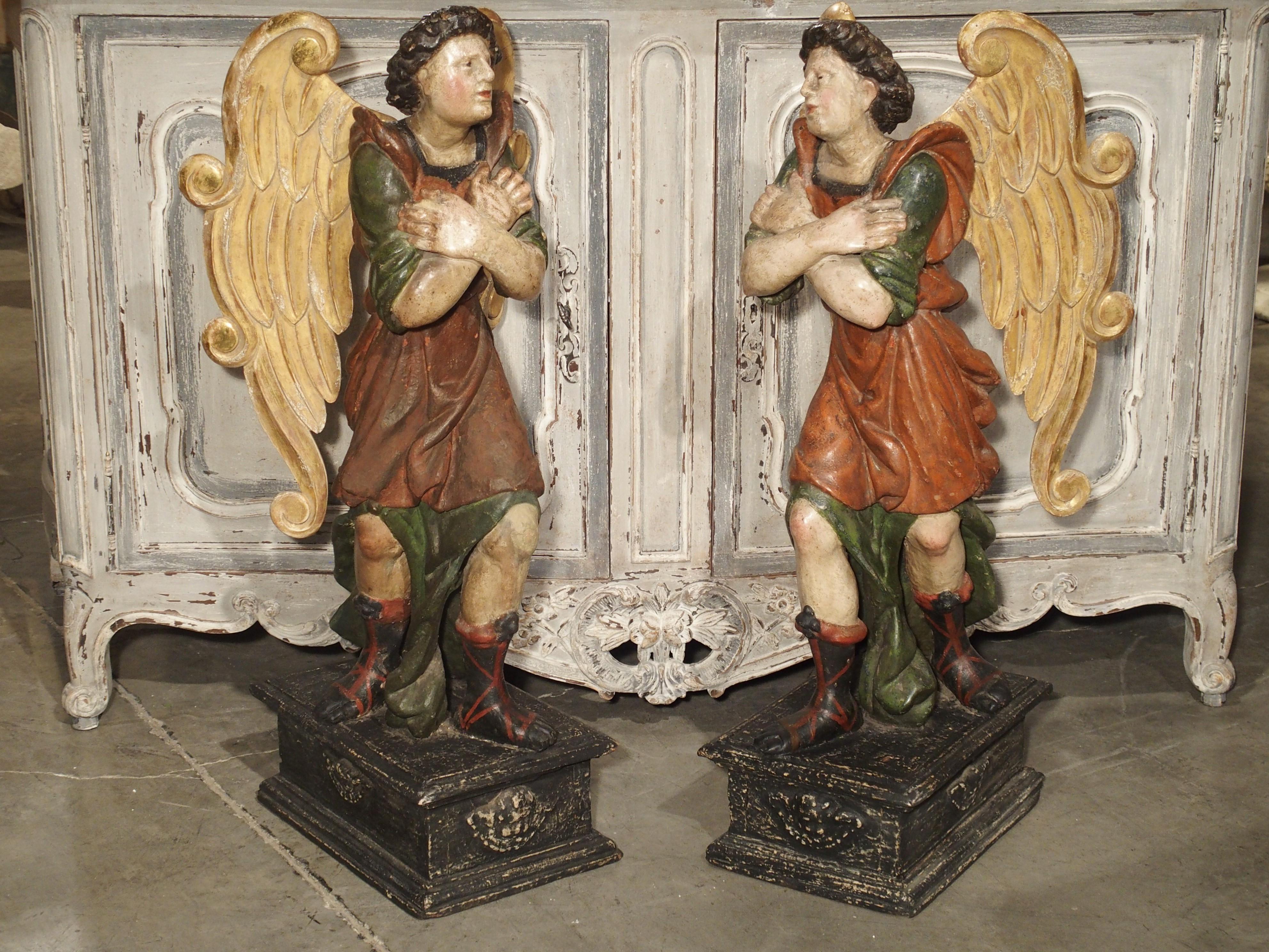 This wonderful pair of polychromed angels on bases are of Italian origin and date to the 17th century. They stand close to 40 inches tall, with their heads up and to the side, and crossed arms over their chest. As a true pair, they stand next to