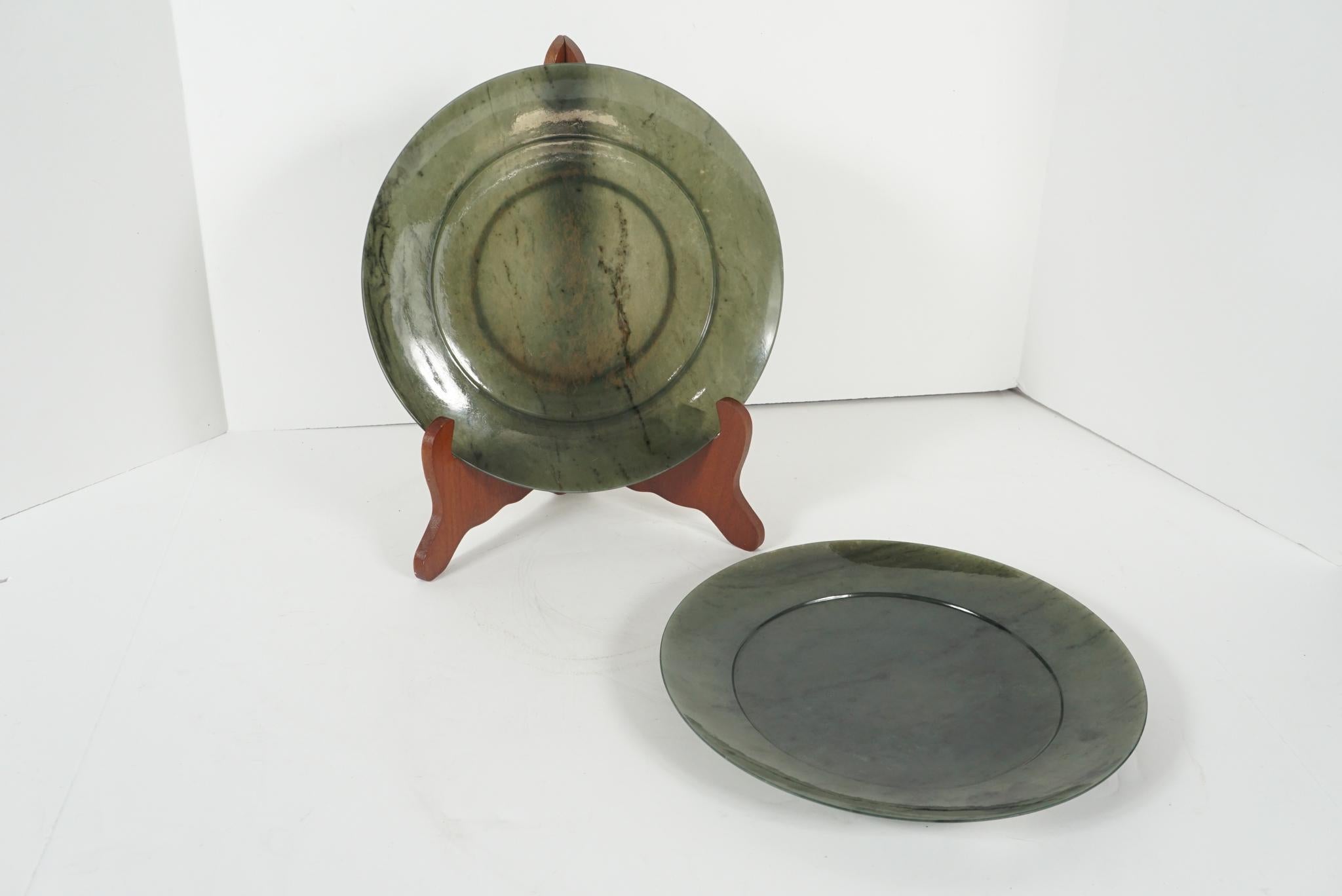 This pair of jade plates are carved in a very delicate thin form allowing the stones natural striations and color to show through. The polish and luster are deep and rich giving the texture of the stone a soft mellow reflective surface. Of