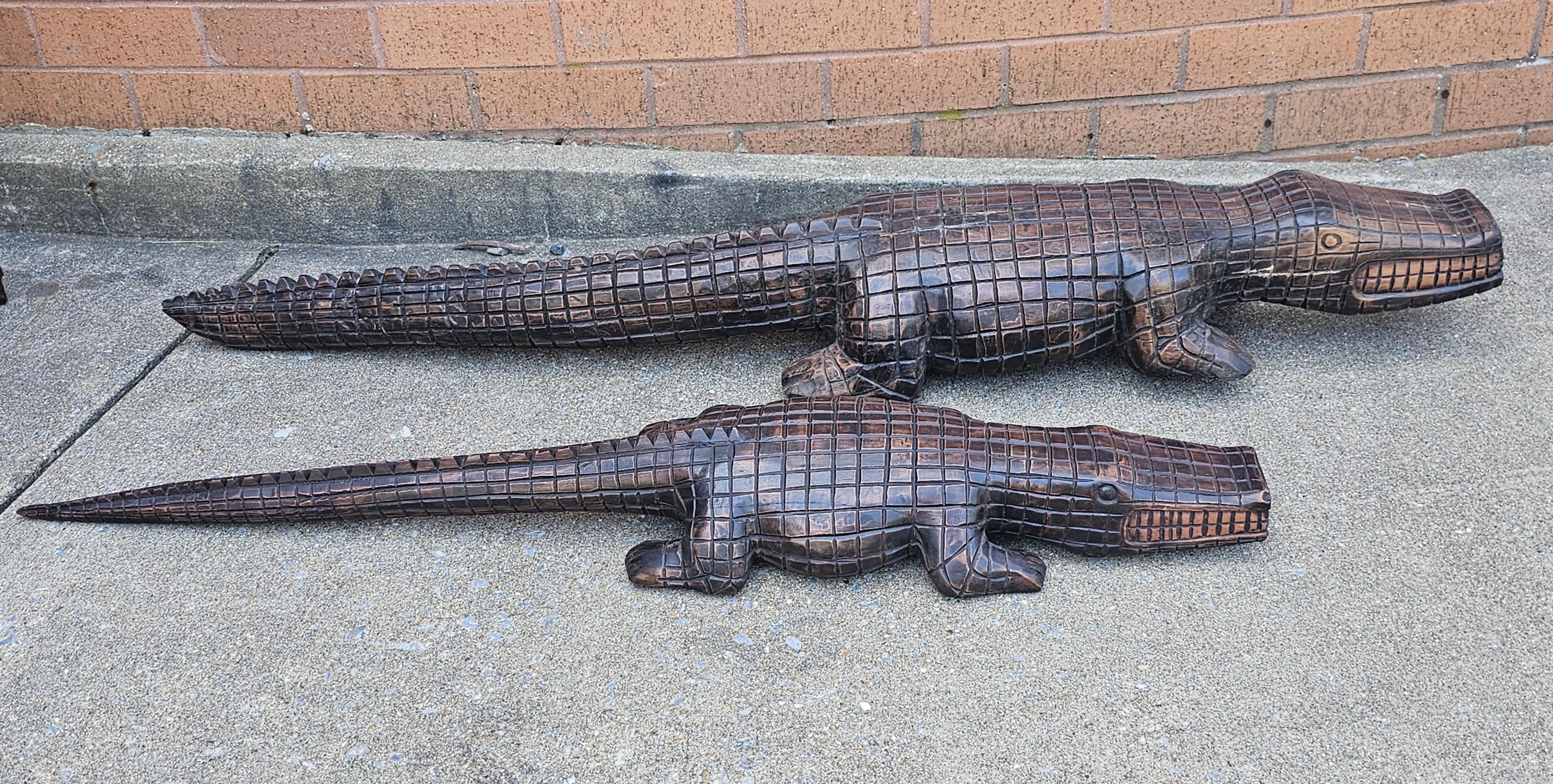 Paire de grands alligators gradués en bois dur sculpté par Racar. 
Dimensions : Plus grand : 52