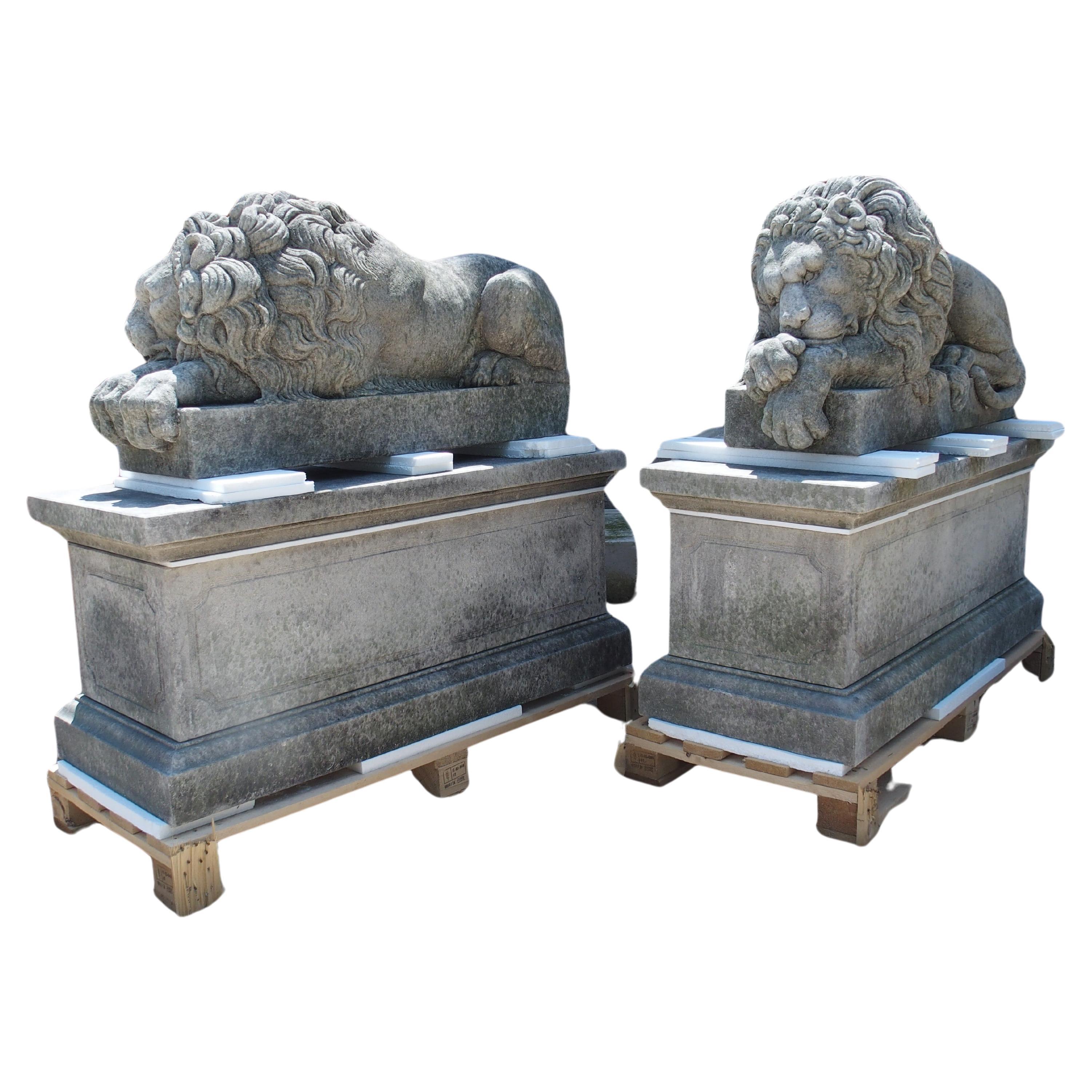 Paire de grands lions sculptés sur des piédestaux, le endormi et le vigilant en vente