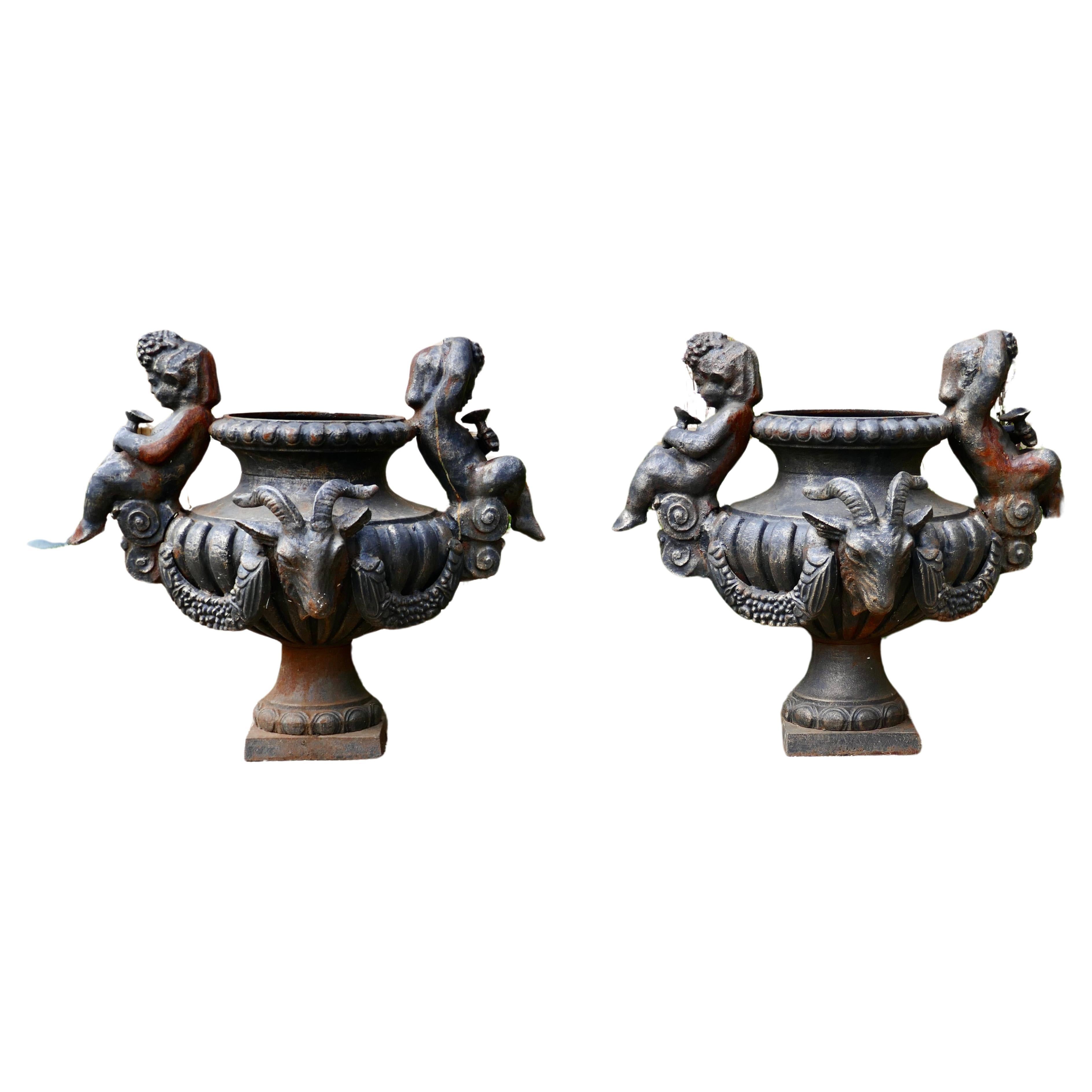 Pair of Large Cast Iron Garden Urns with Rams and Putti For Sale