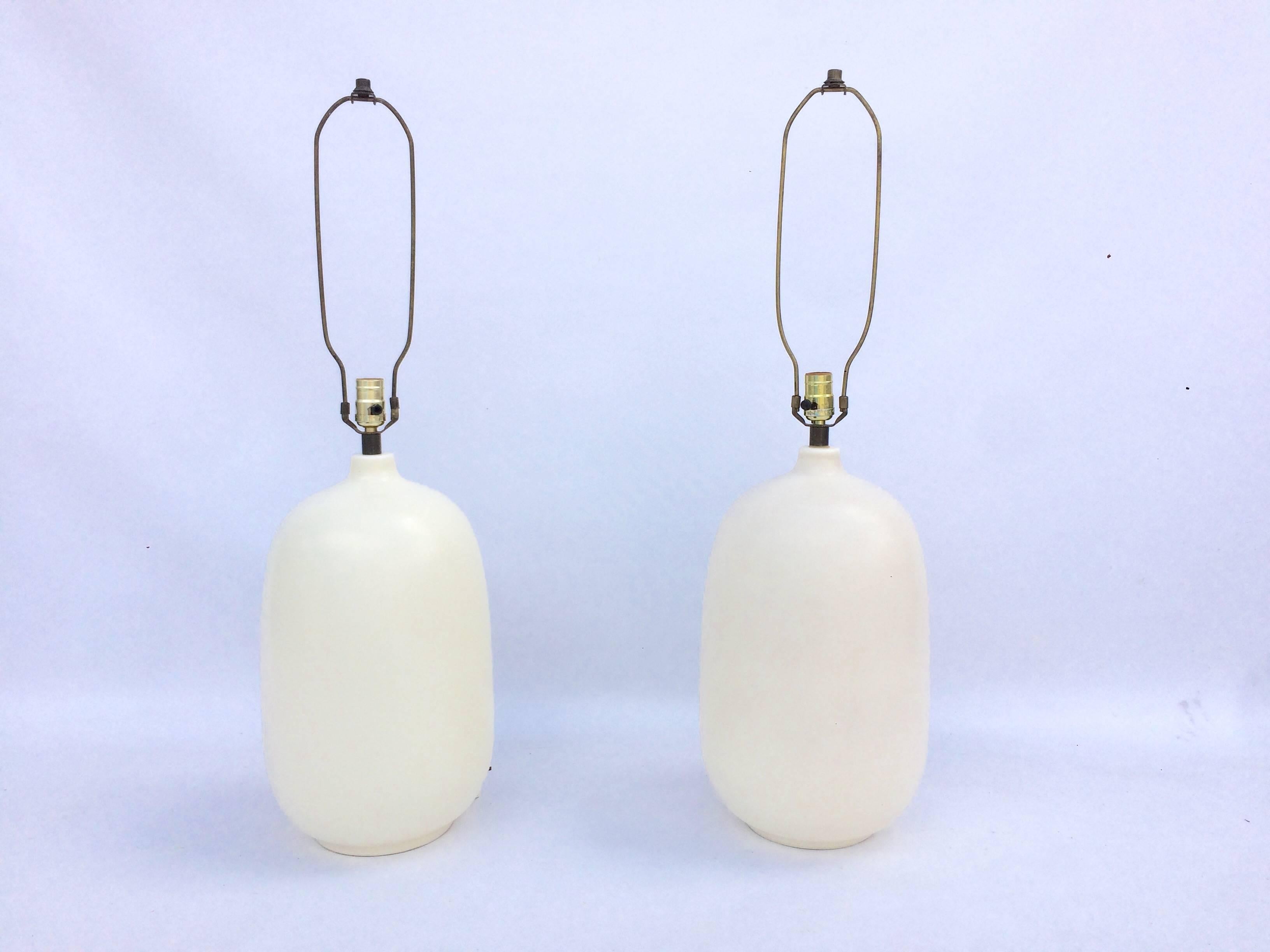 Pair of large ceramic lamps with white shades. One ceramic base is a little darker then the other. Please see all pictures. Linen shades are new.