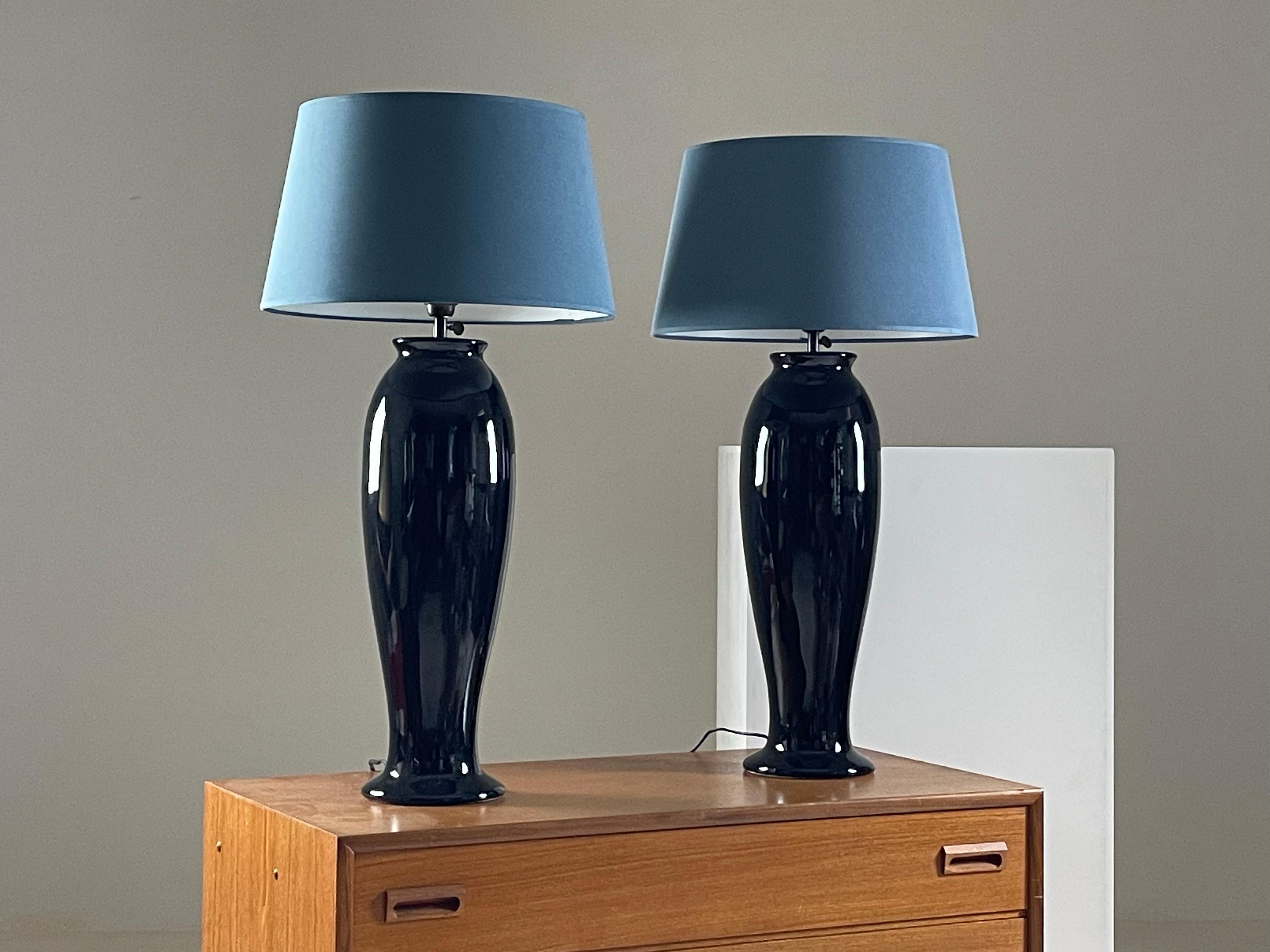 Coppia di grandi lampade in ceramica nera del decoratore Yves Halard. Ogni lampada è sormontata dal suo paralume blu. Il tutto è in condizioni eccellenti. Dimensioni: altezza dei piedi 58 cm. Diametro della gamba 16 cm. Altezza totale con paralume